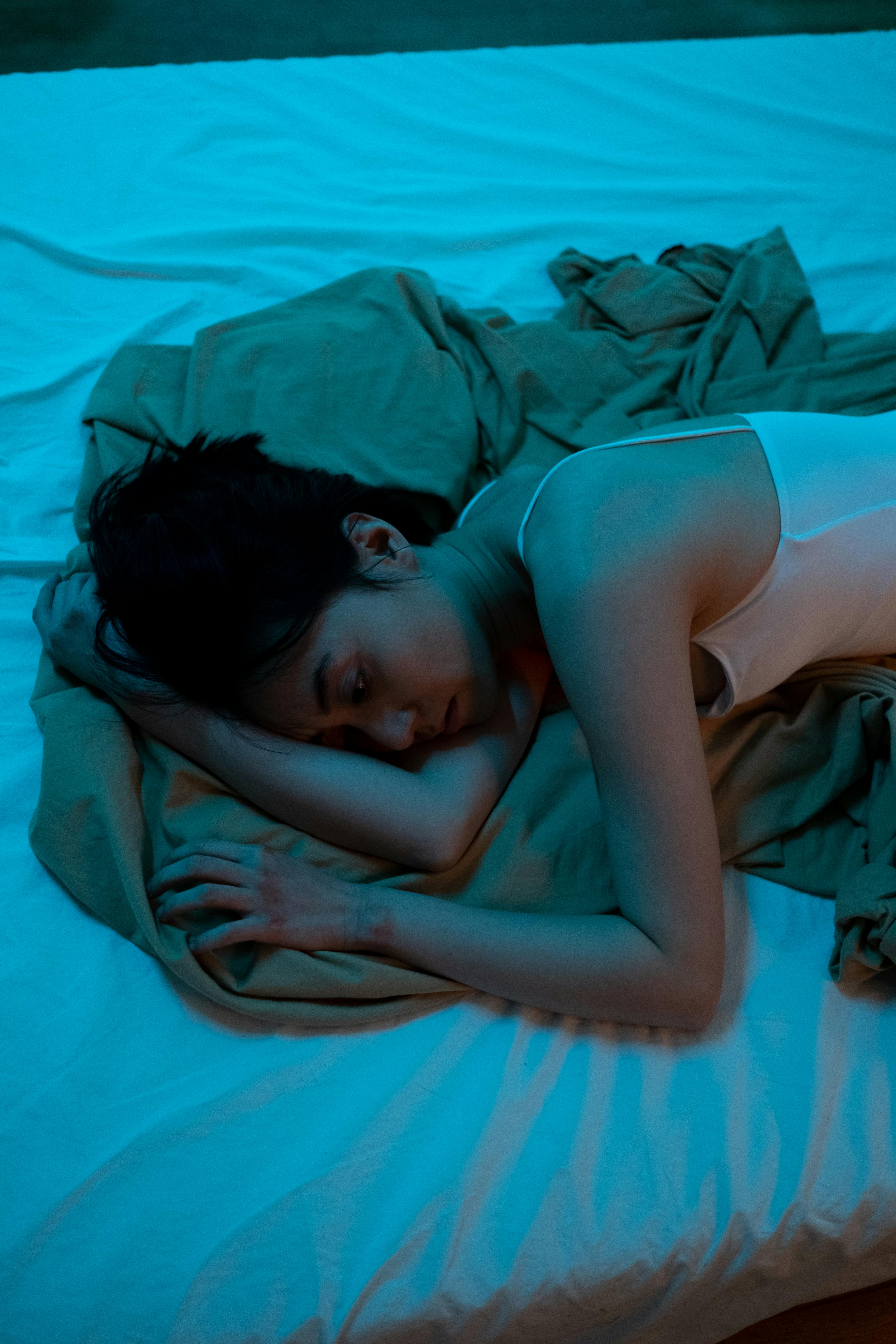 An upset and miserable woman lying alone in bed | Source: Pexels