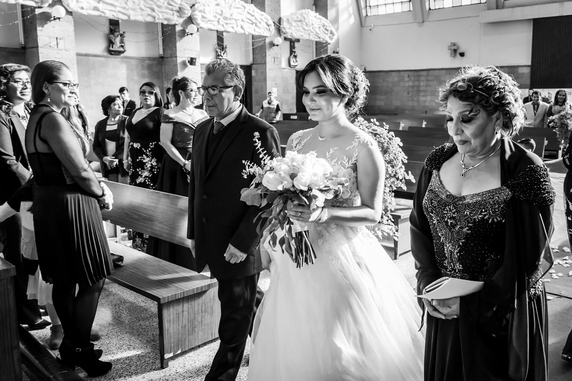 Grayscale shot of a delighted bride walking down the aisle | Source: Pexels