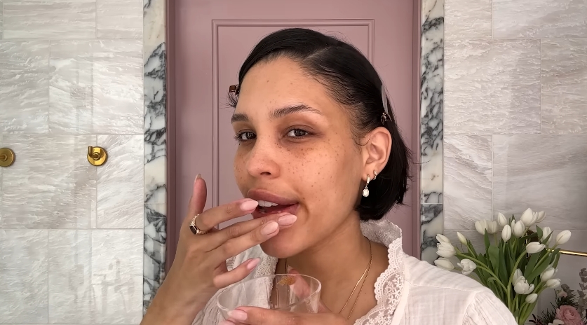 Nara Smith applying her homemade lip scrub from a video dated December 12, 2024. | Source: YouTube/Vogue