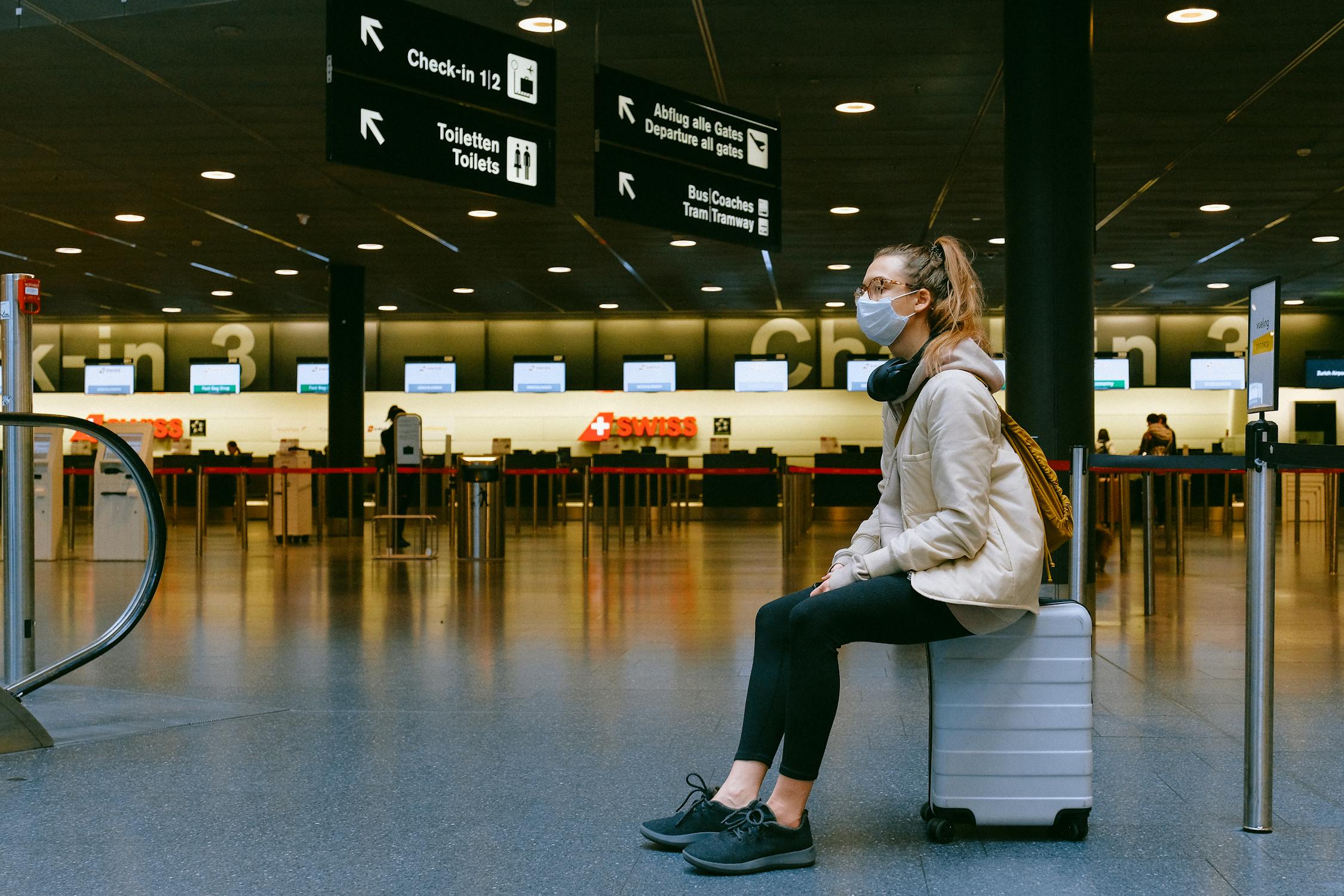 A woman sitting on a suitcase | Source: Pexels