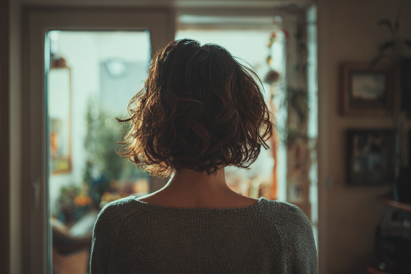 A woman standing in her house | Source: Midjourney