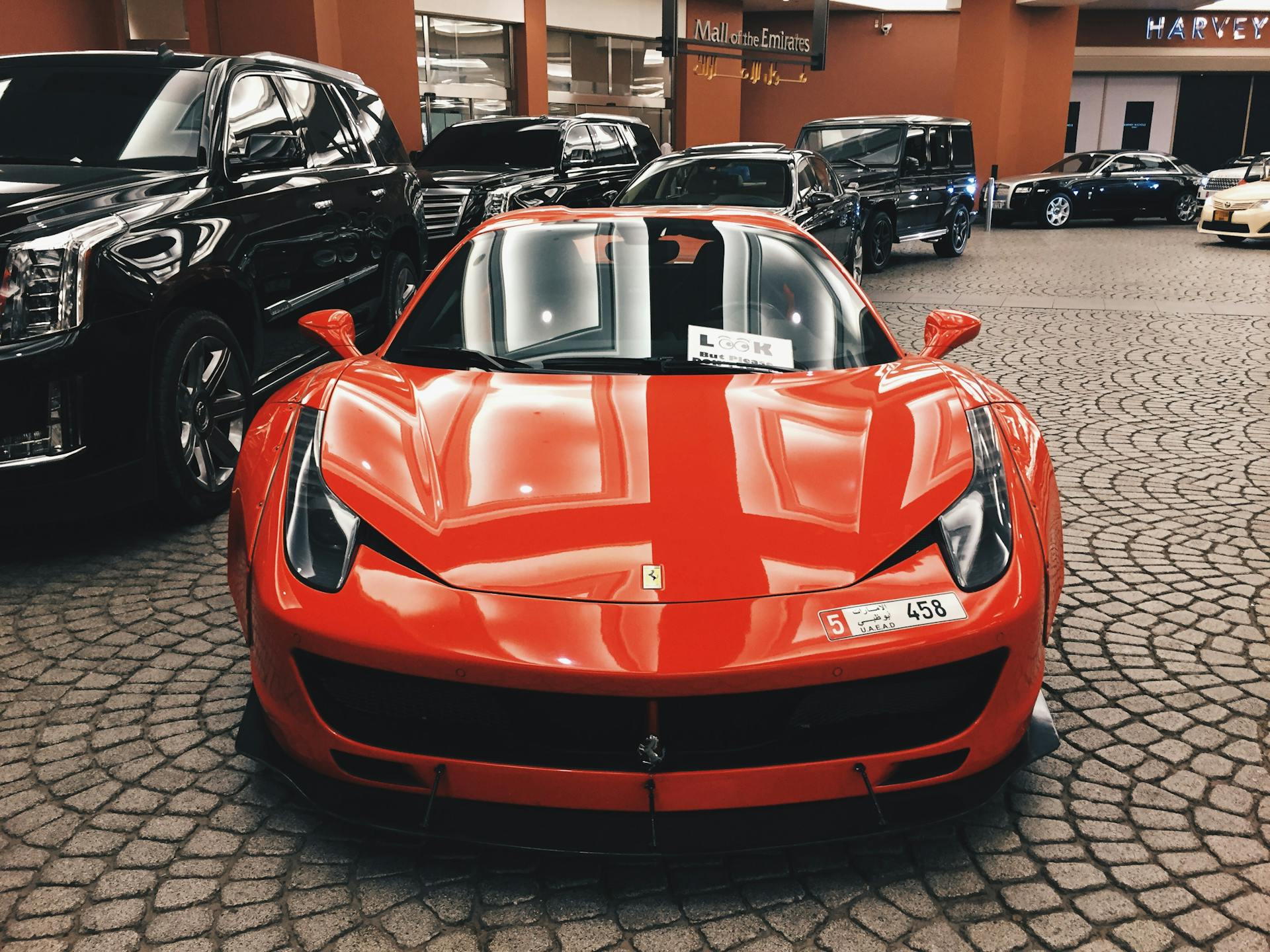 A front view of a red car parked in a lot with other cars in the background | Source: Pexels