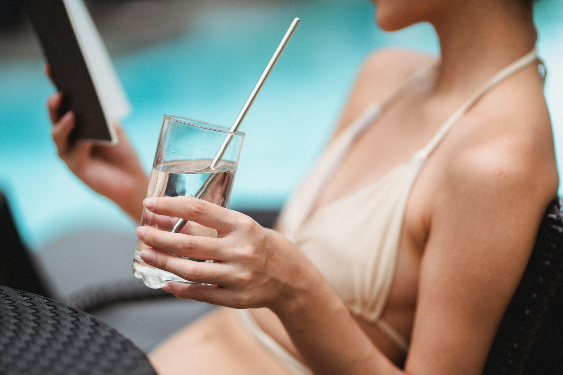 Uma mulher lendo à beira da piscina | Fonte: Pexels