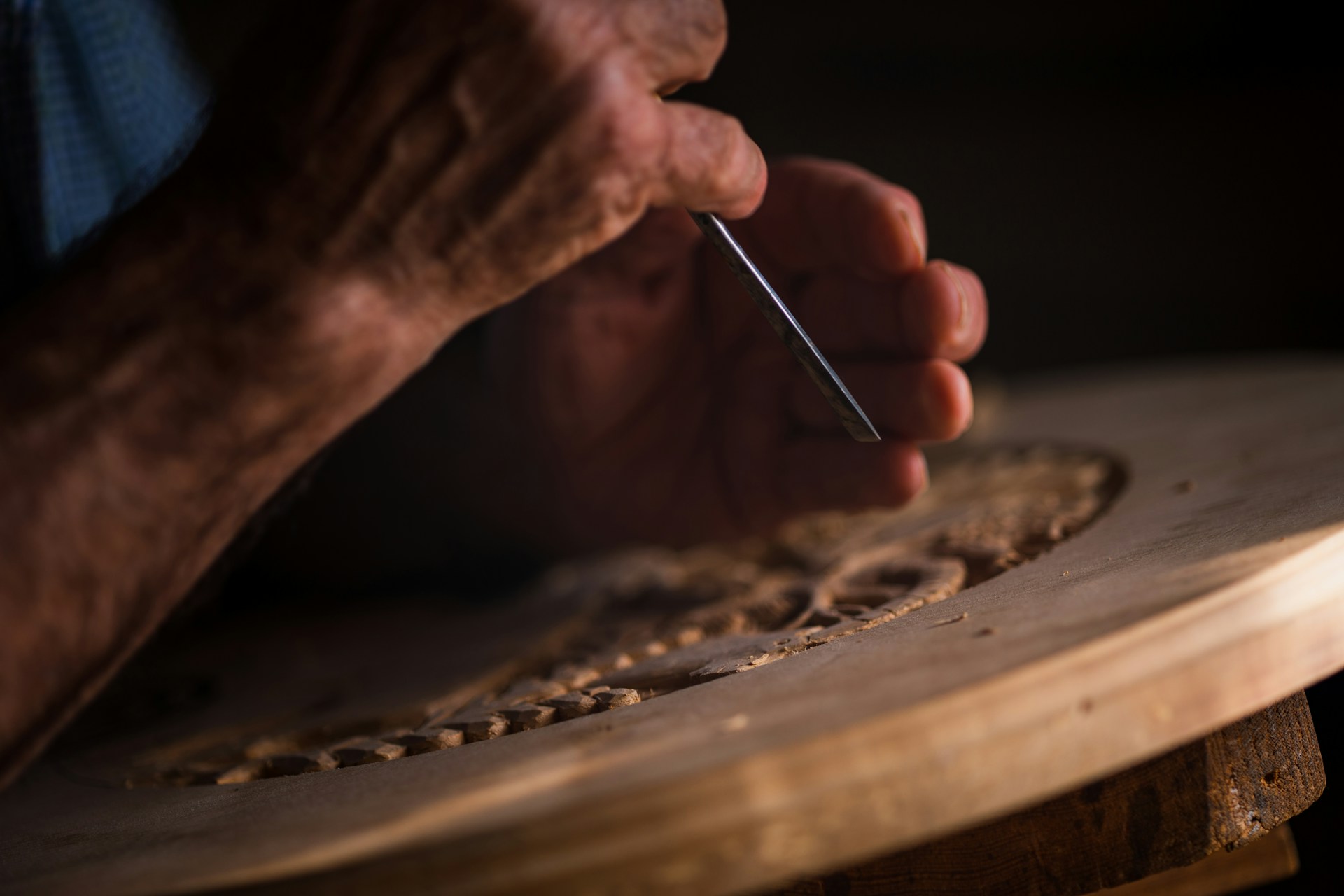 A man carving a design onto a piece of wood | Source: Unsplash
