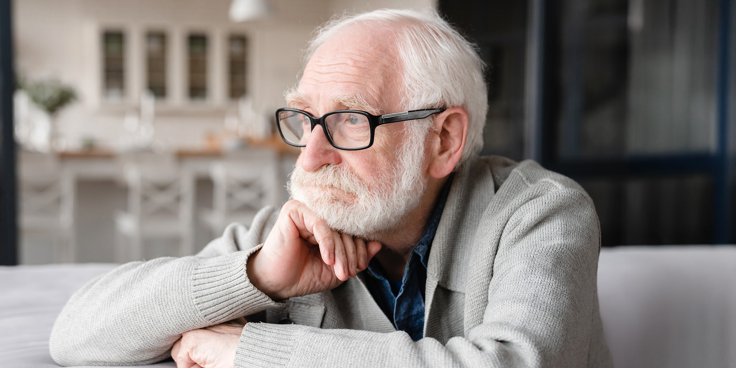 A sad old man sitting on a couch | Source: Shutterstock