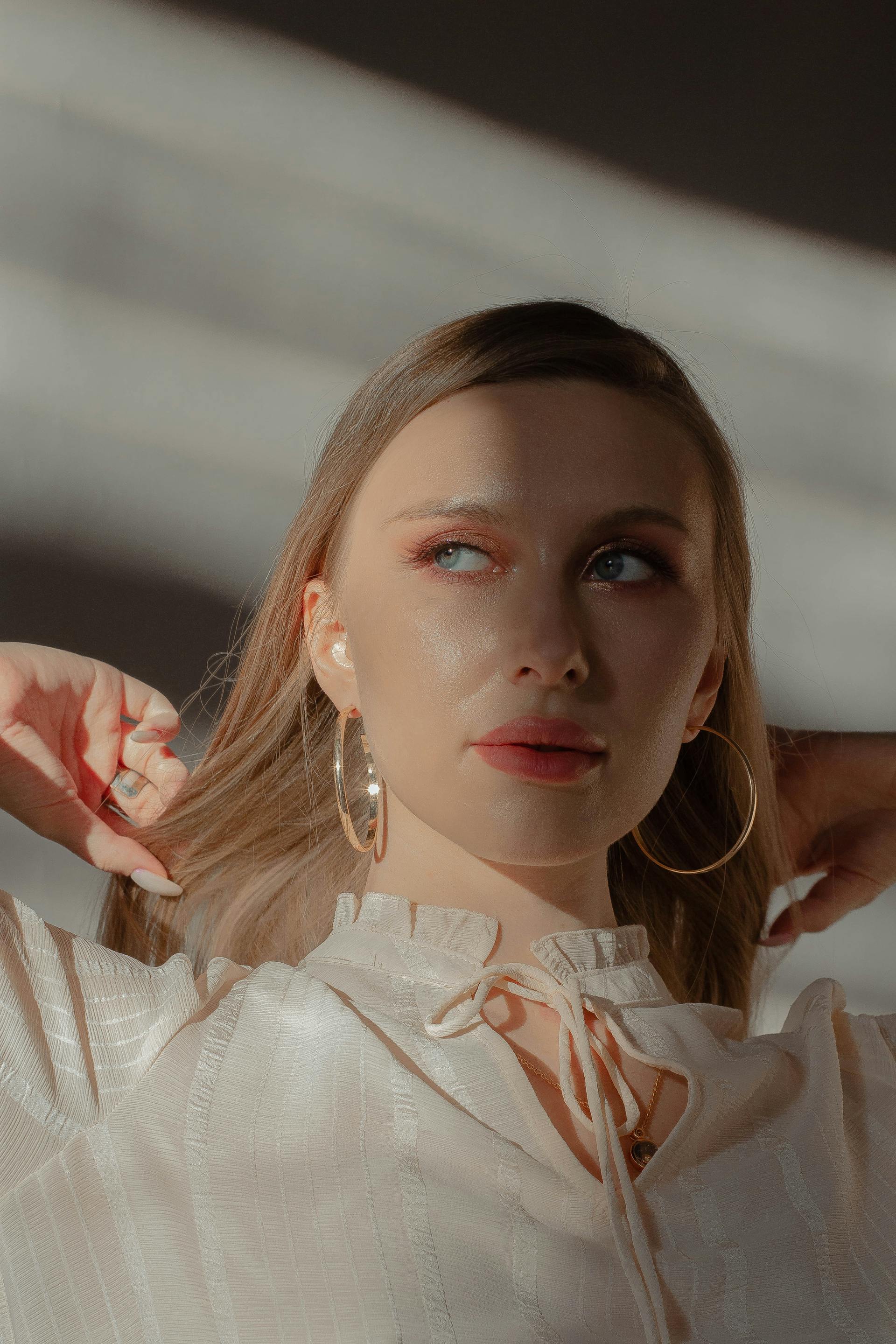 A beautiful woman with large hoop earrings and a golden necklace frowning | Source: Pexels