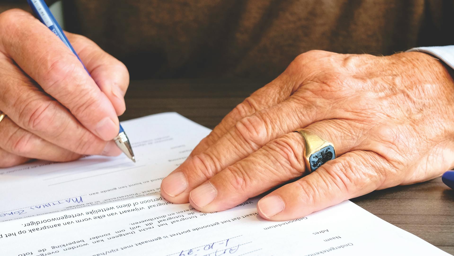 Une personne qui signe un document | Source : Pexels