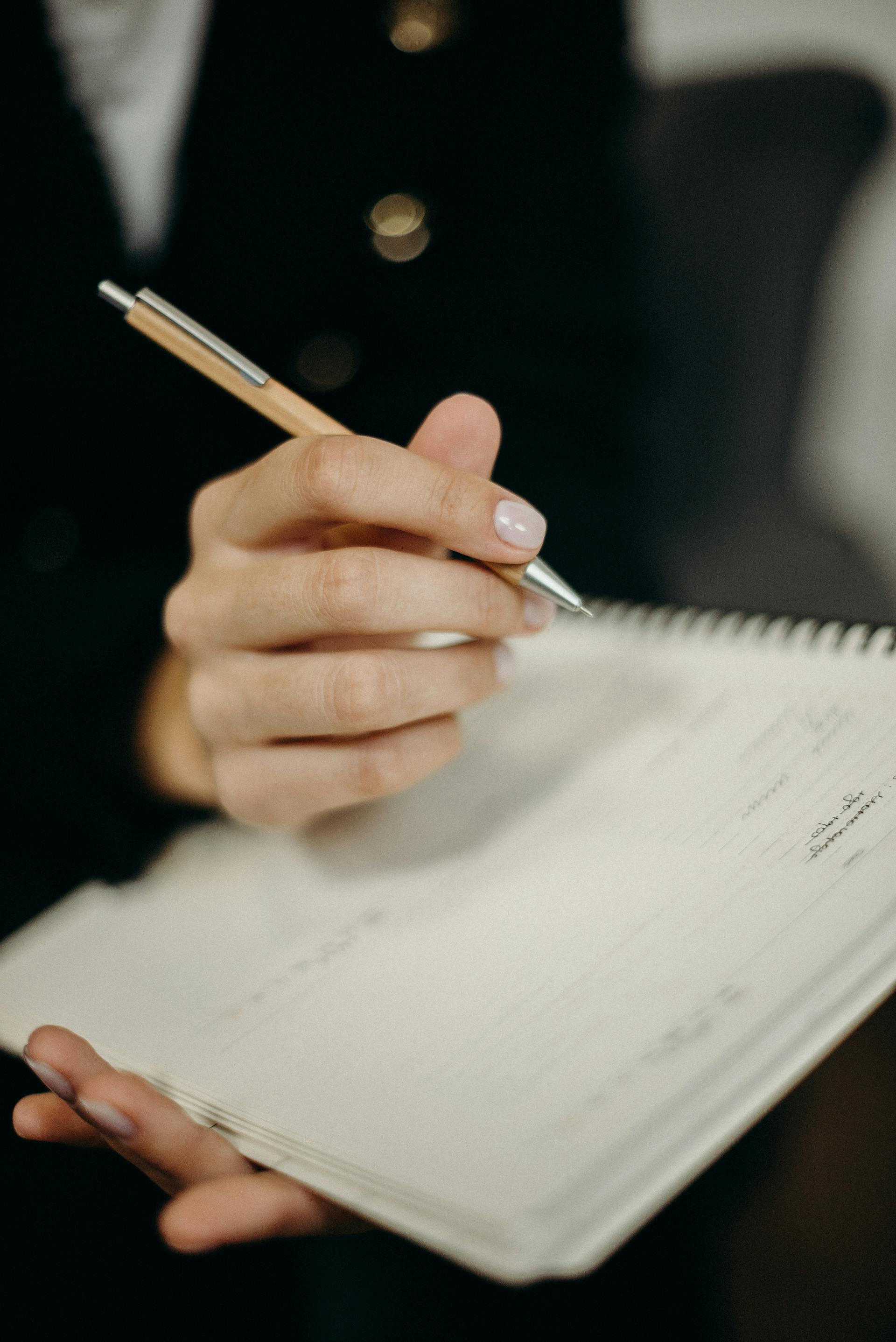 A woman writing in a notebook | Source: Pexels