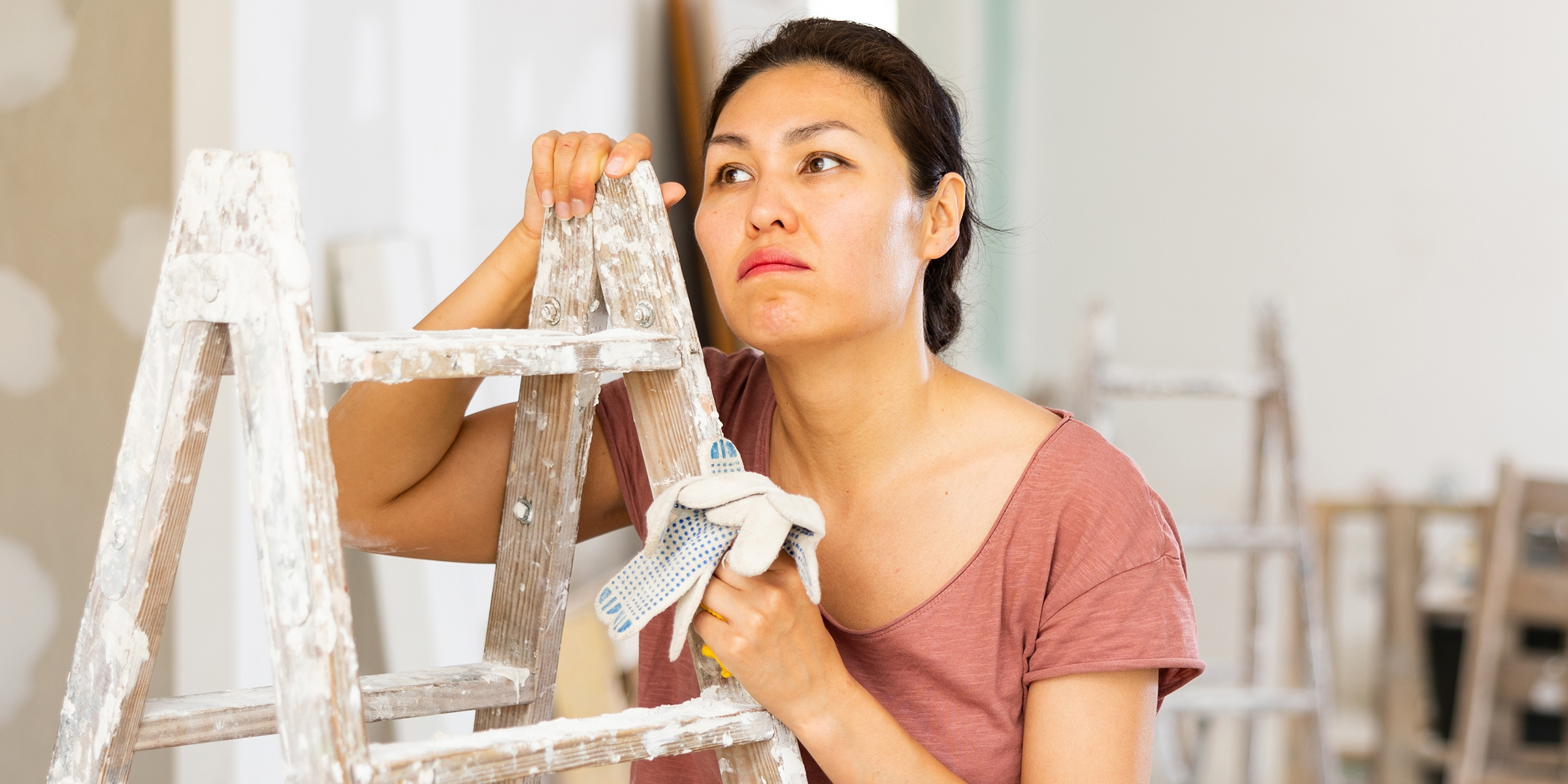 A woman holding a ladder | Source: Shutterstock