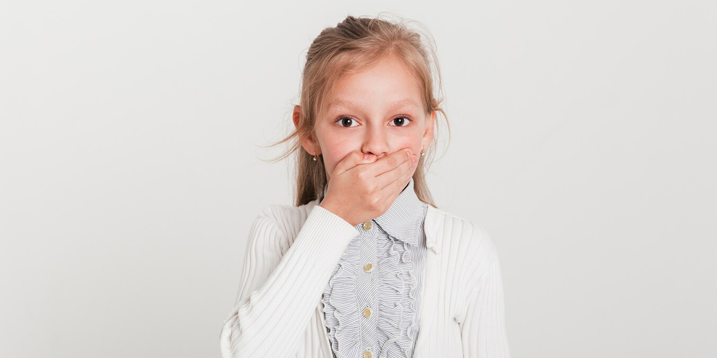 A girl covering her mouth | Source: Freepik