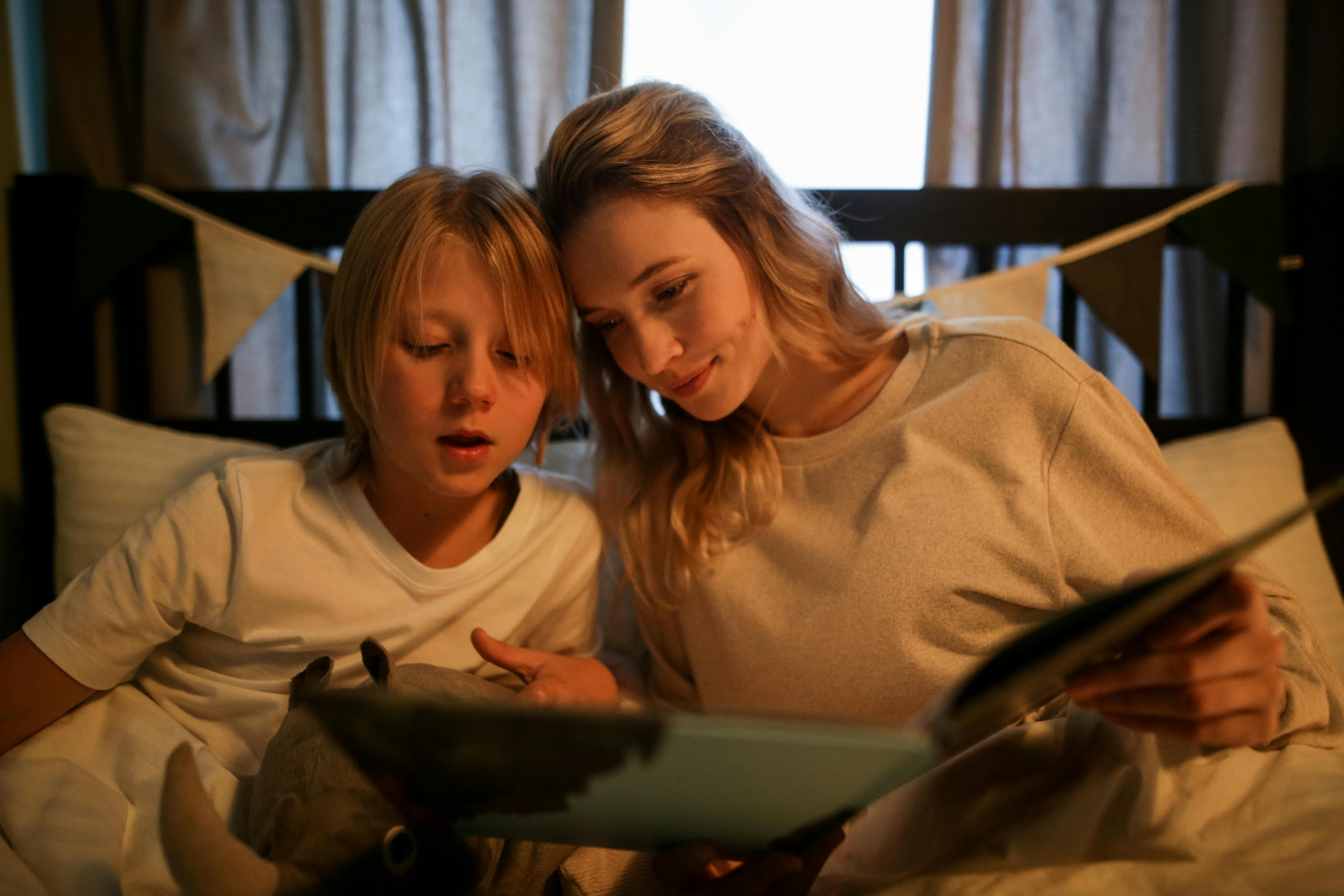 A woman and a boy reading together | Source: Pexels