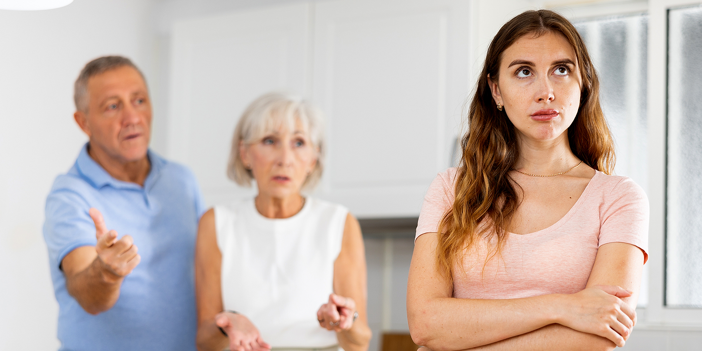 An elderly couple talking to their young daughter | Source: Shutterstock