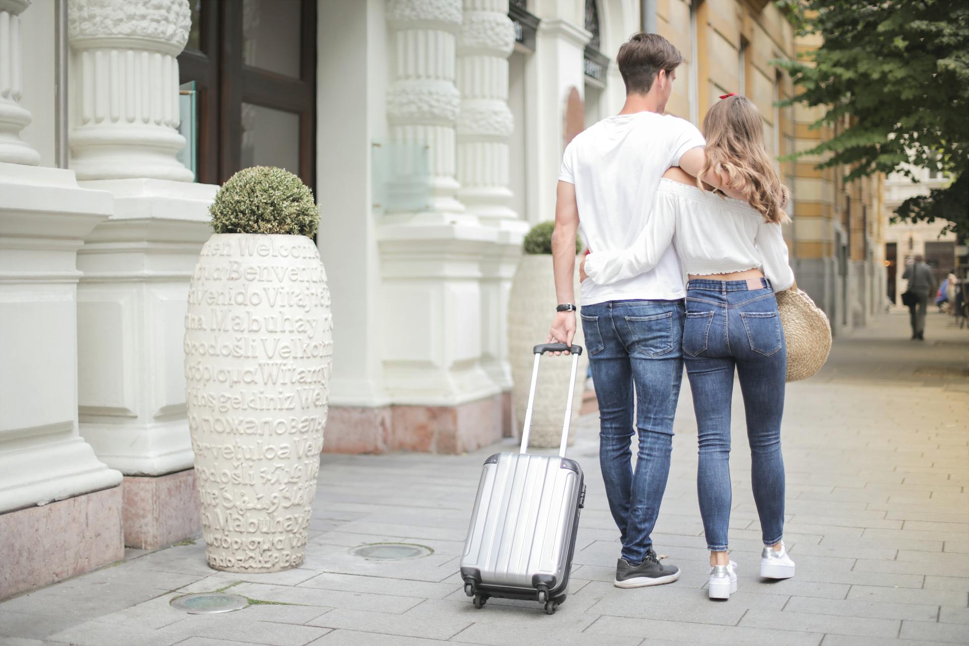 A couple walking on the street with their luggage | Source: Pexels