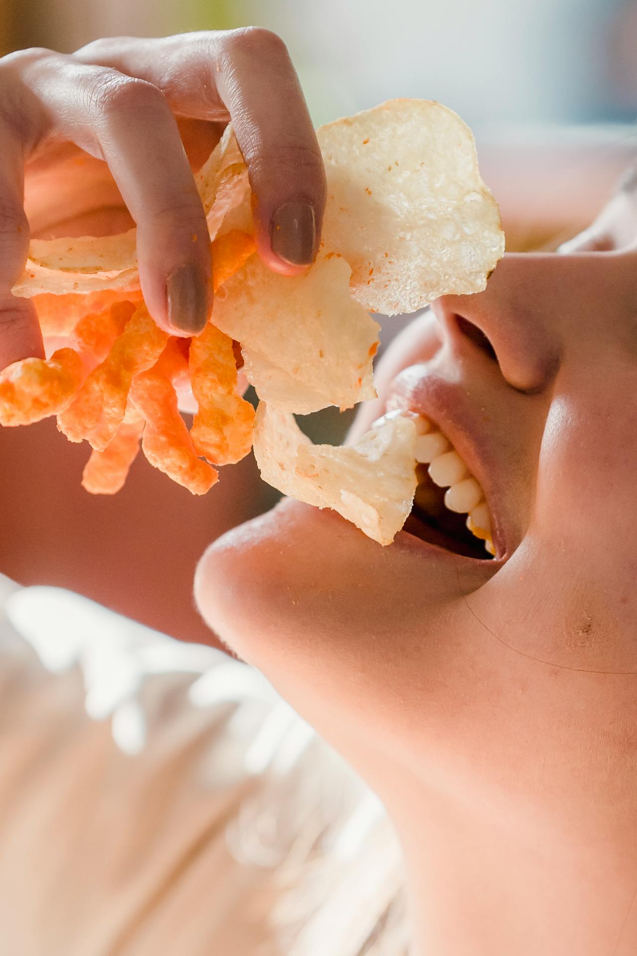 A woman eating crispy snacks | Source: Pexels