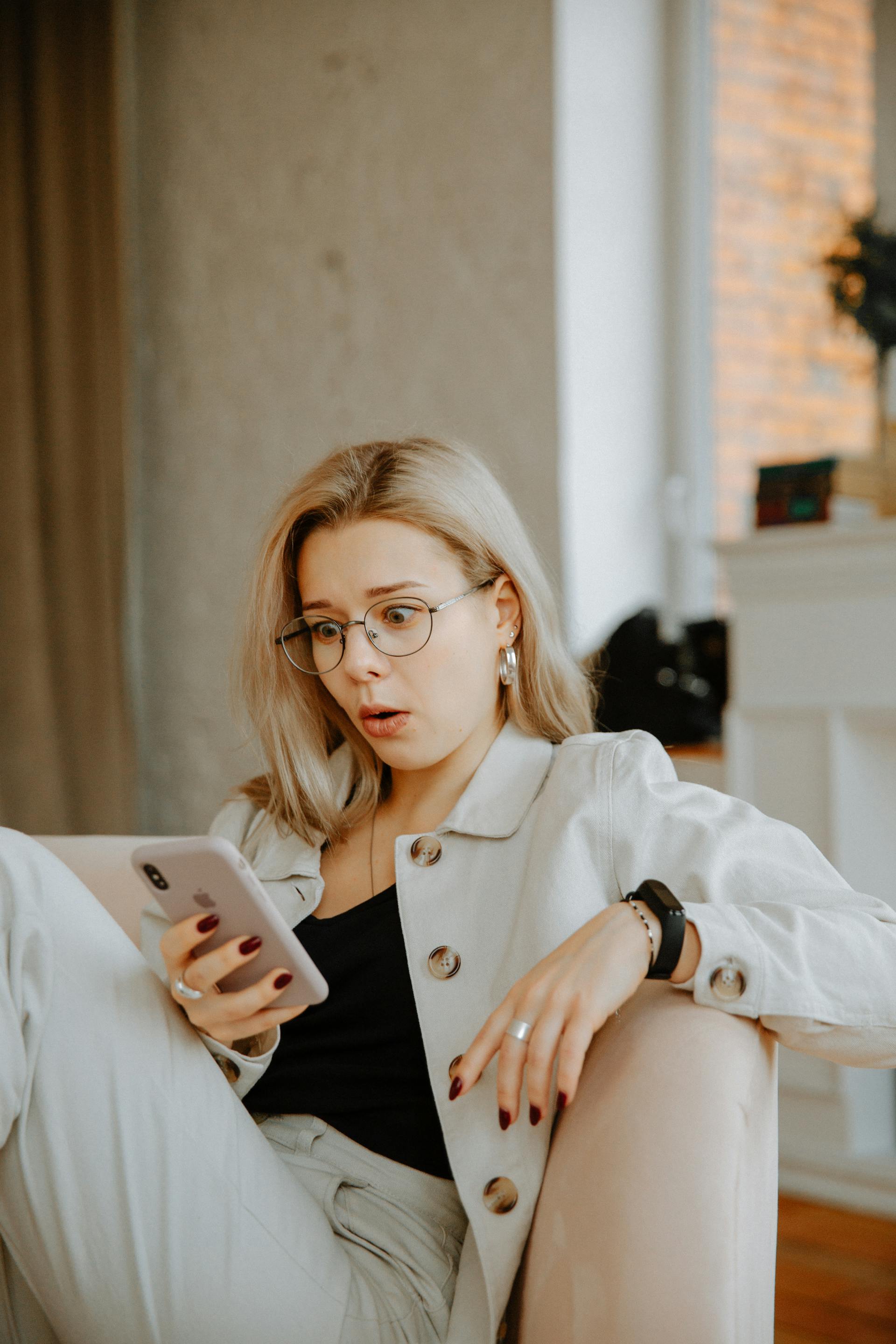 Uma mulher olhando para o celular em choque | Fonte: Pexels