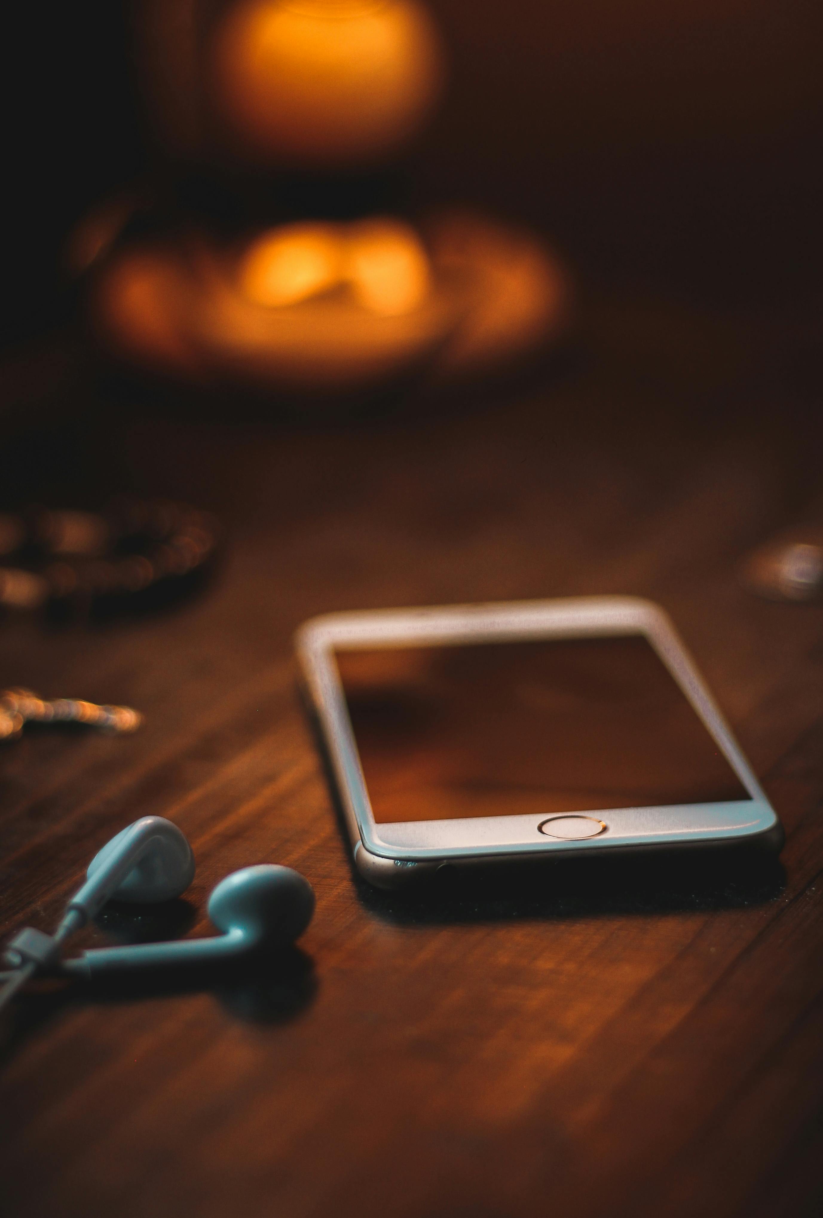 A phone and earbuds on a table | Source: Pexels