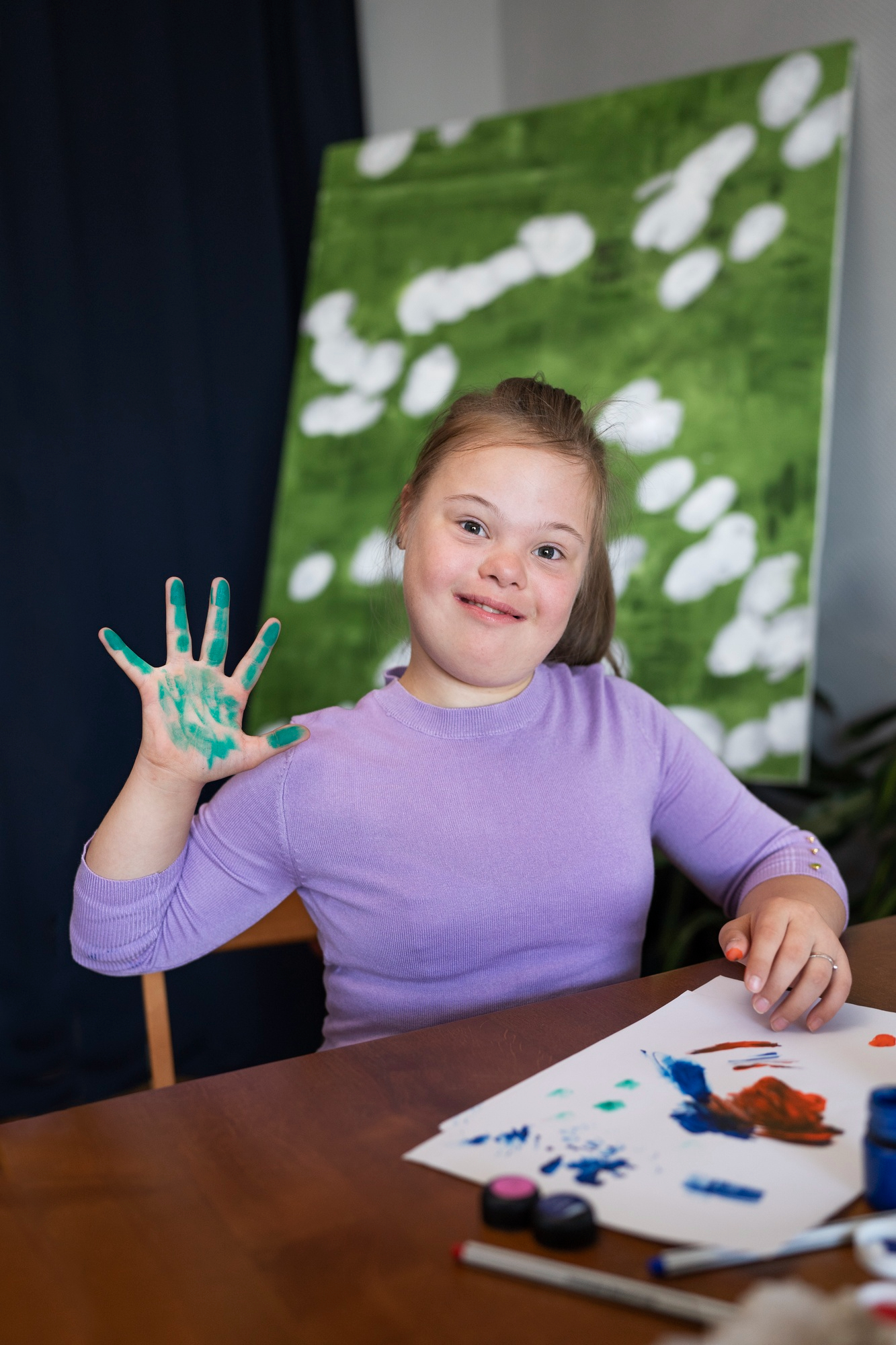 A girl with Down syndrome painting | Source: Freepik