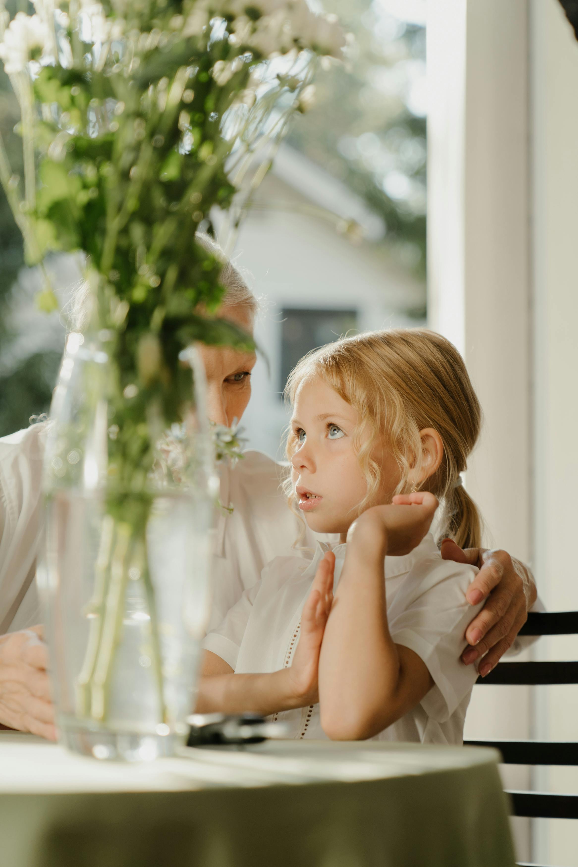 A older woman and a girl beside a flower vase on a table | Source: Pexels