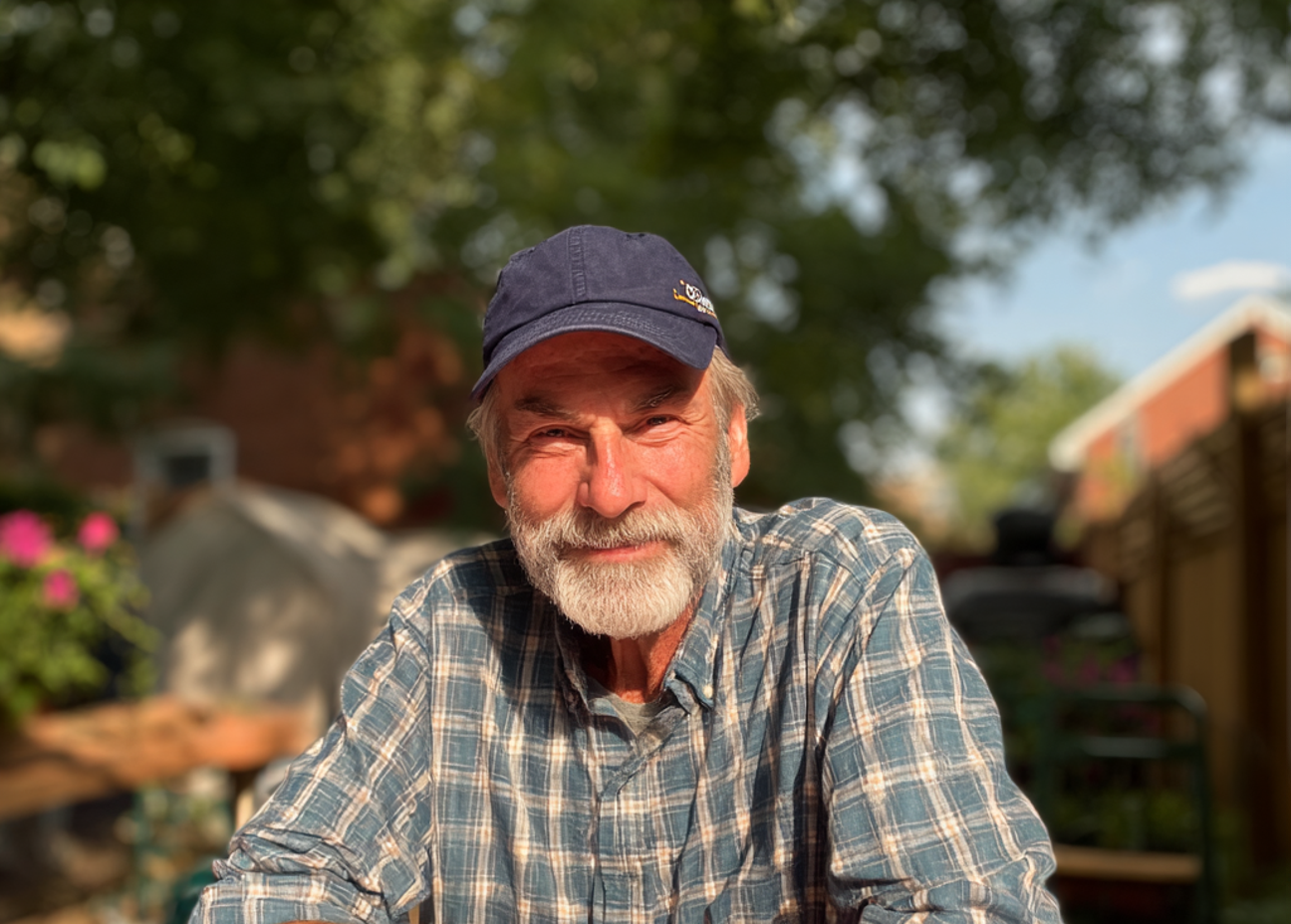 A smiling older man sitting at a table | Source: Midjourney