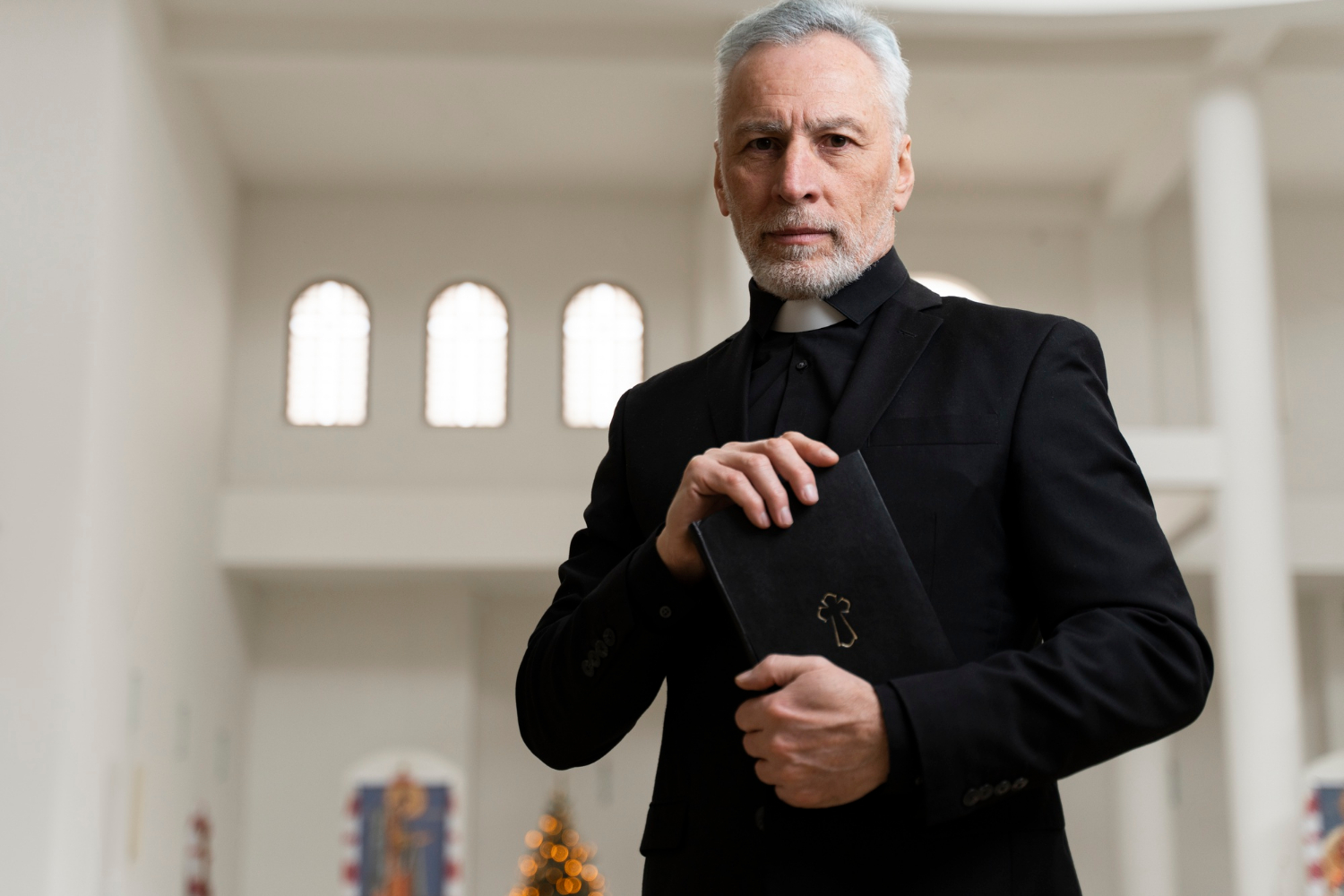 A priest holding a holy book | Source: Freepik