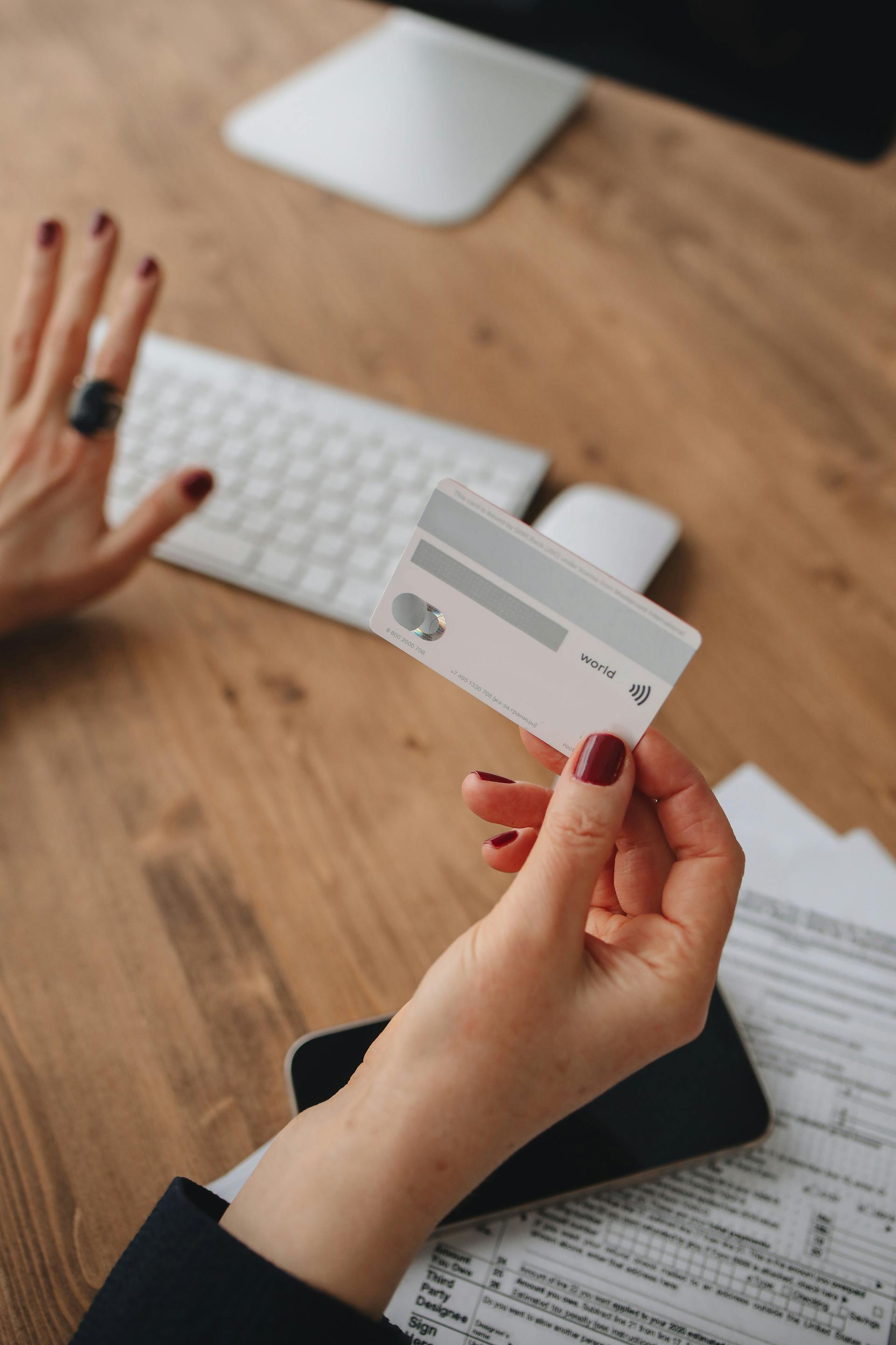A woman holding a credit card | Source: Pexels
