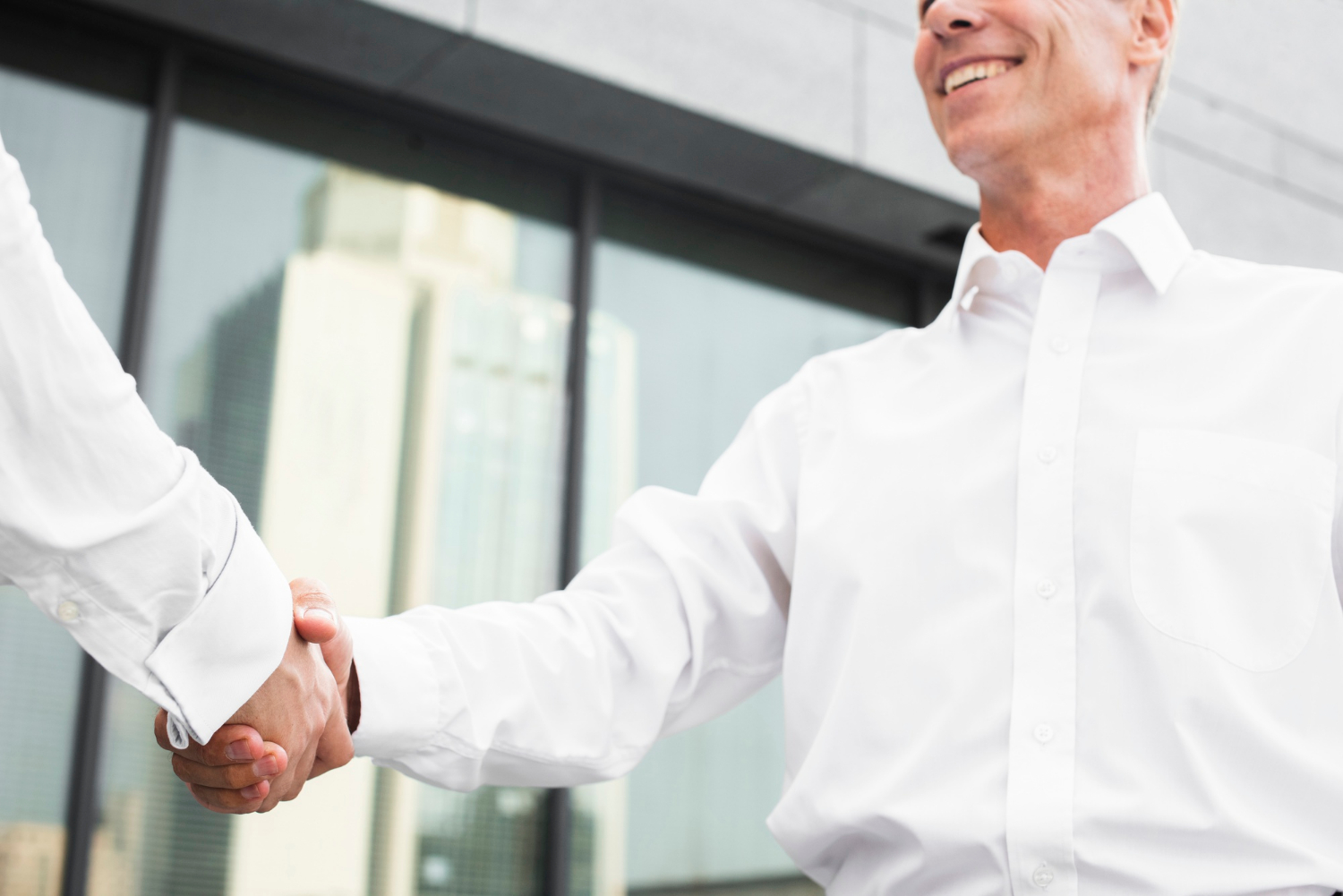 An elegant businessman shaking hands with another man | Source: Freepik