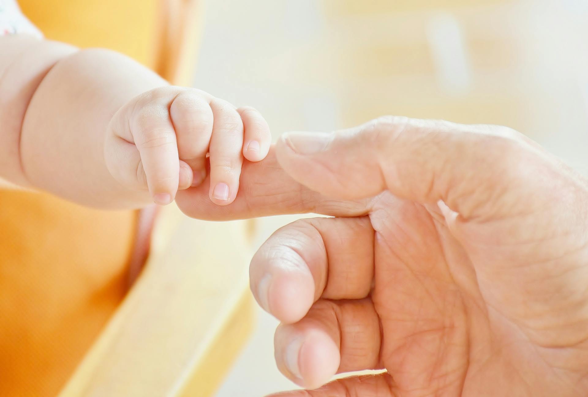 A baby holding a man's finger | Source: Pexels