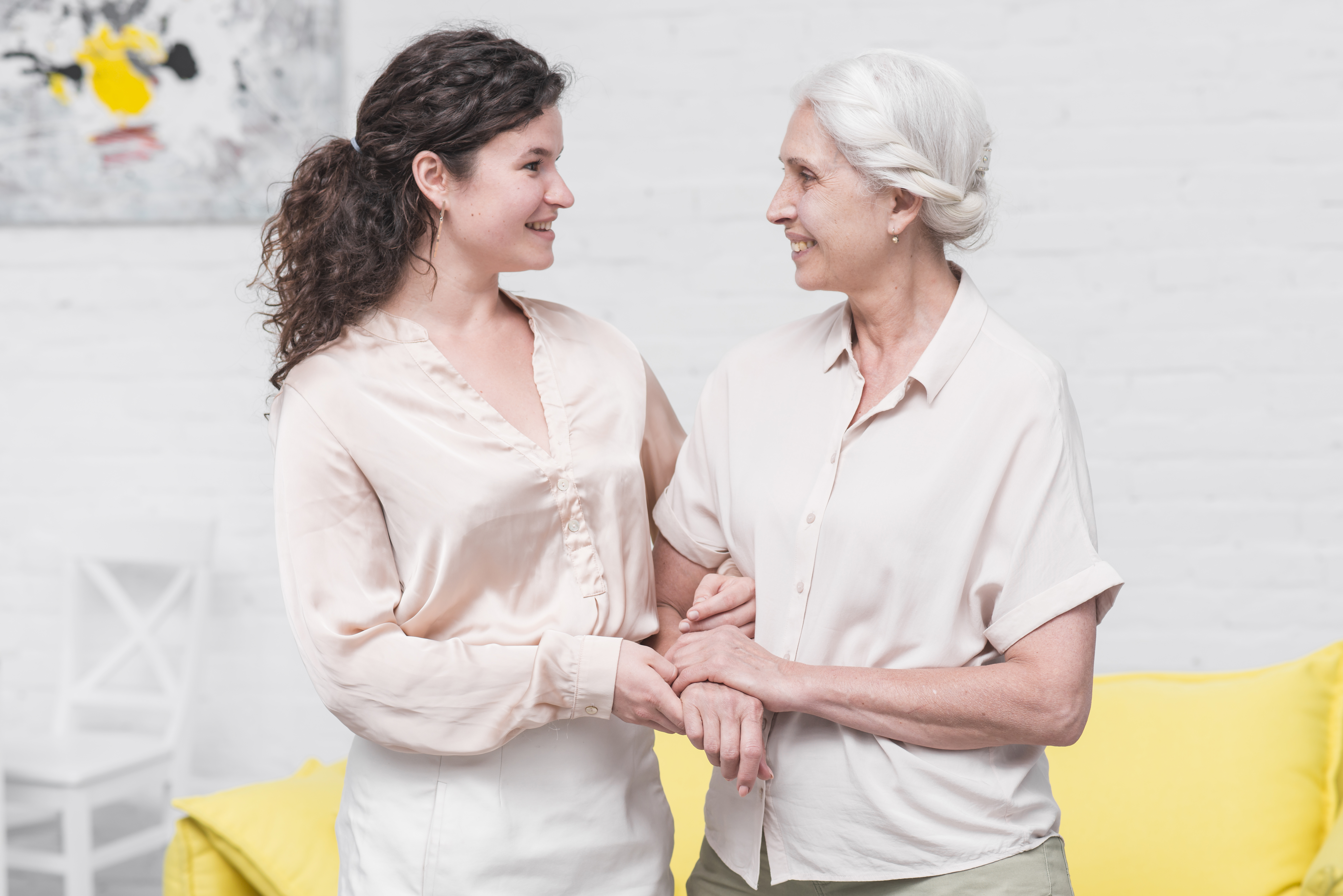 A senior woman smiling with a younger woman | Source: Freepik