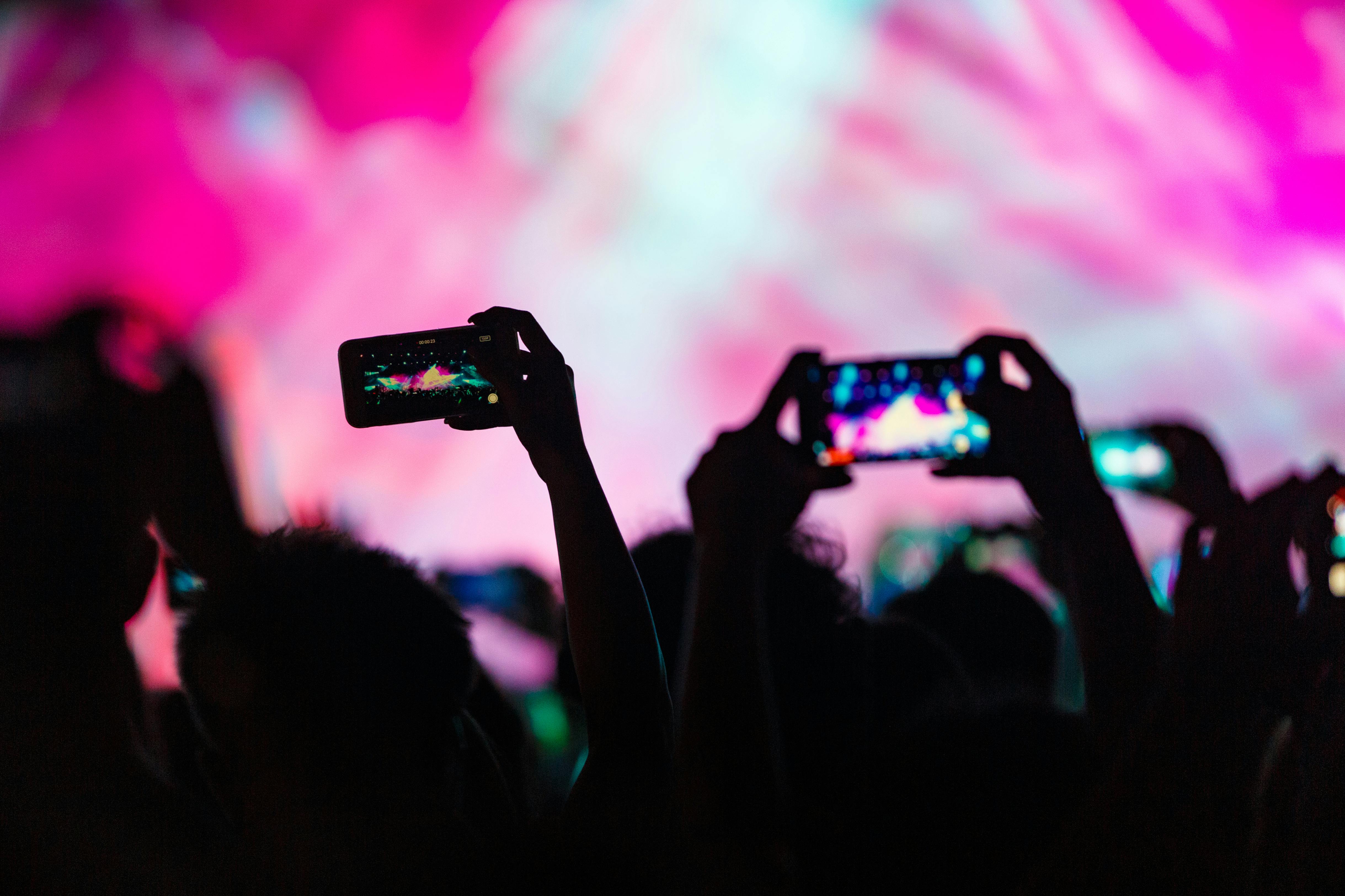 People holding up their phones to record and take pictures | Source: Pexels