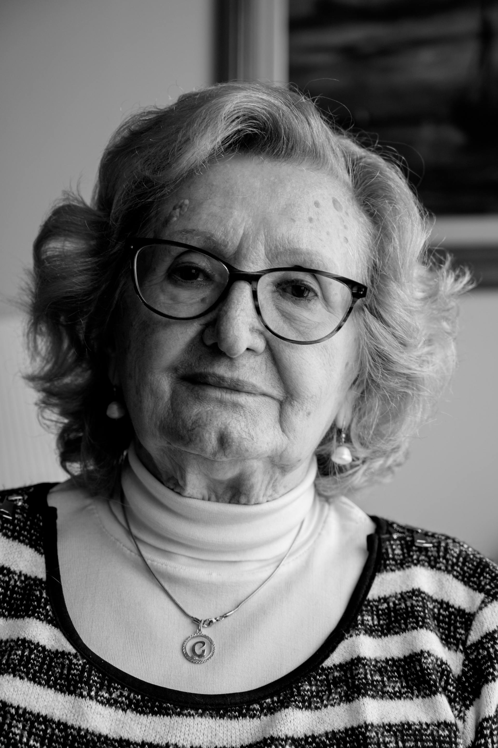 A black and white portrait of an elderly woman wearing glasses and a striped sweater | Source: Pexels