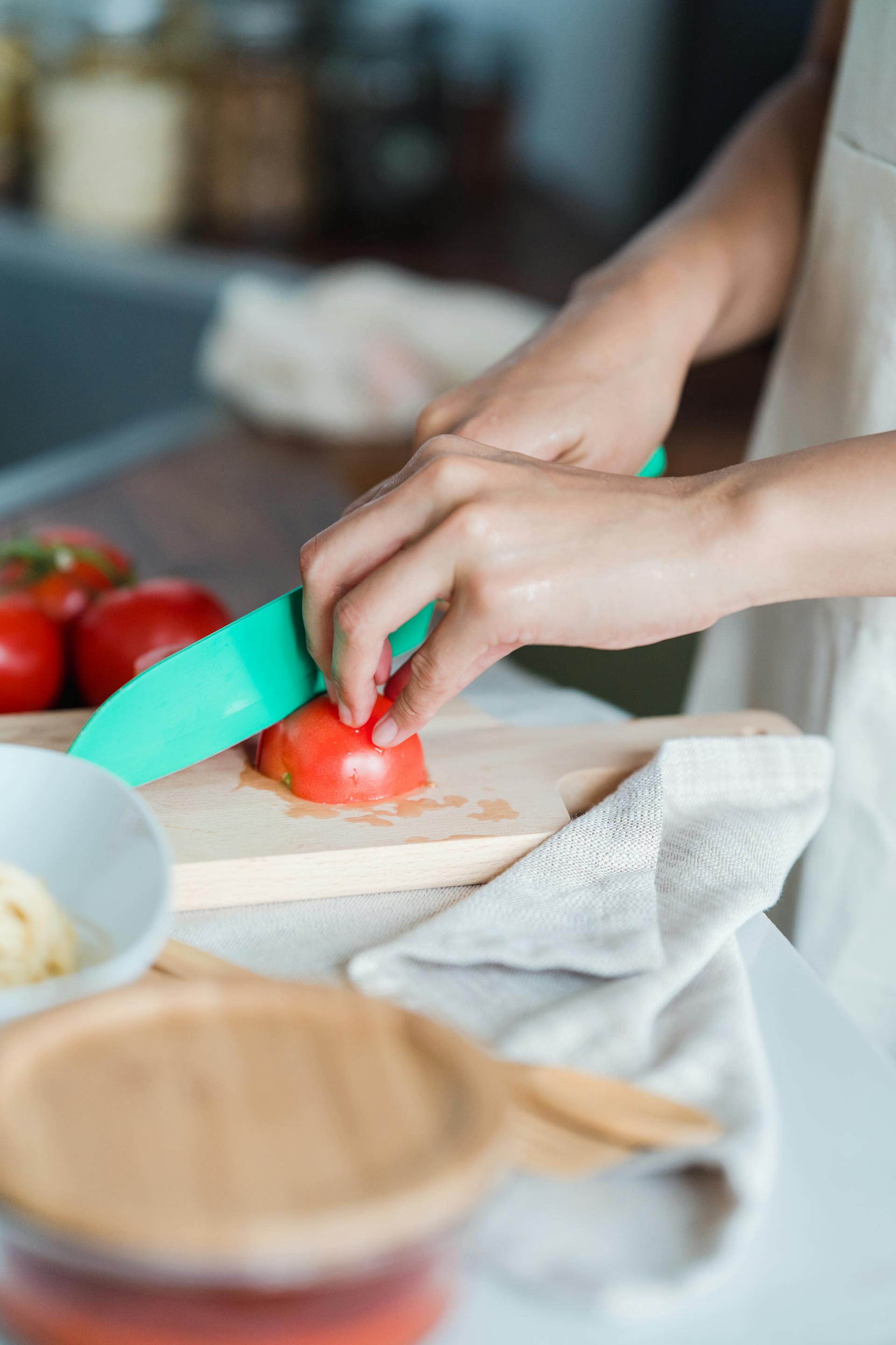 A person slicing tomatoes | Source: Pexels