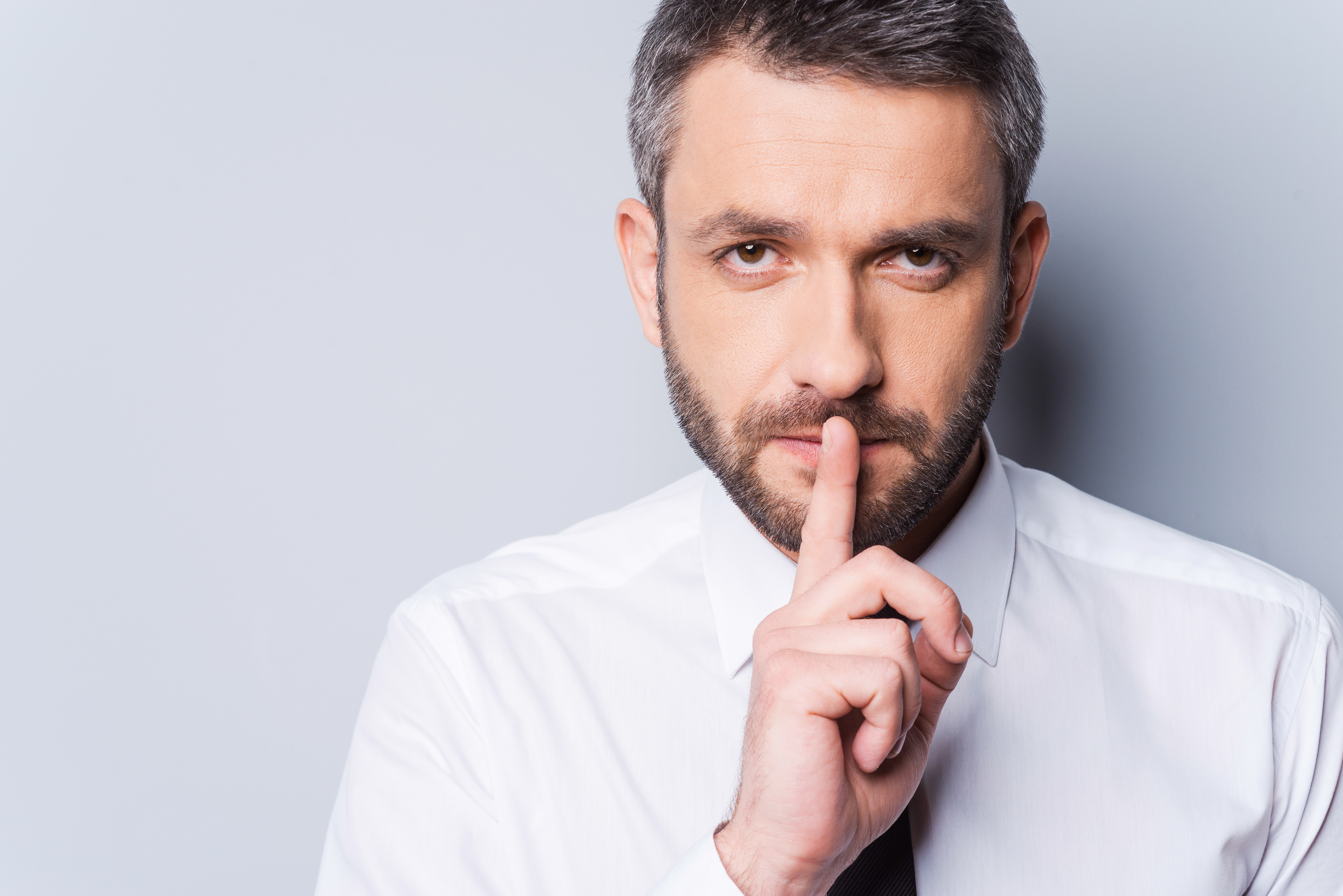 Man gesturing secrecy | Source: Shutterstock