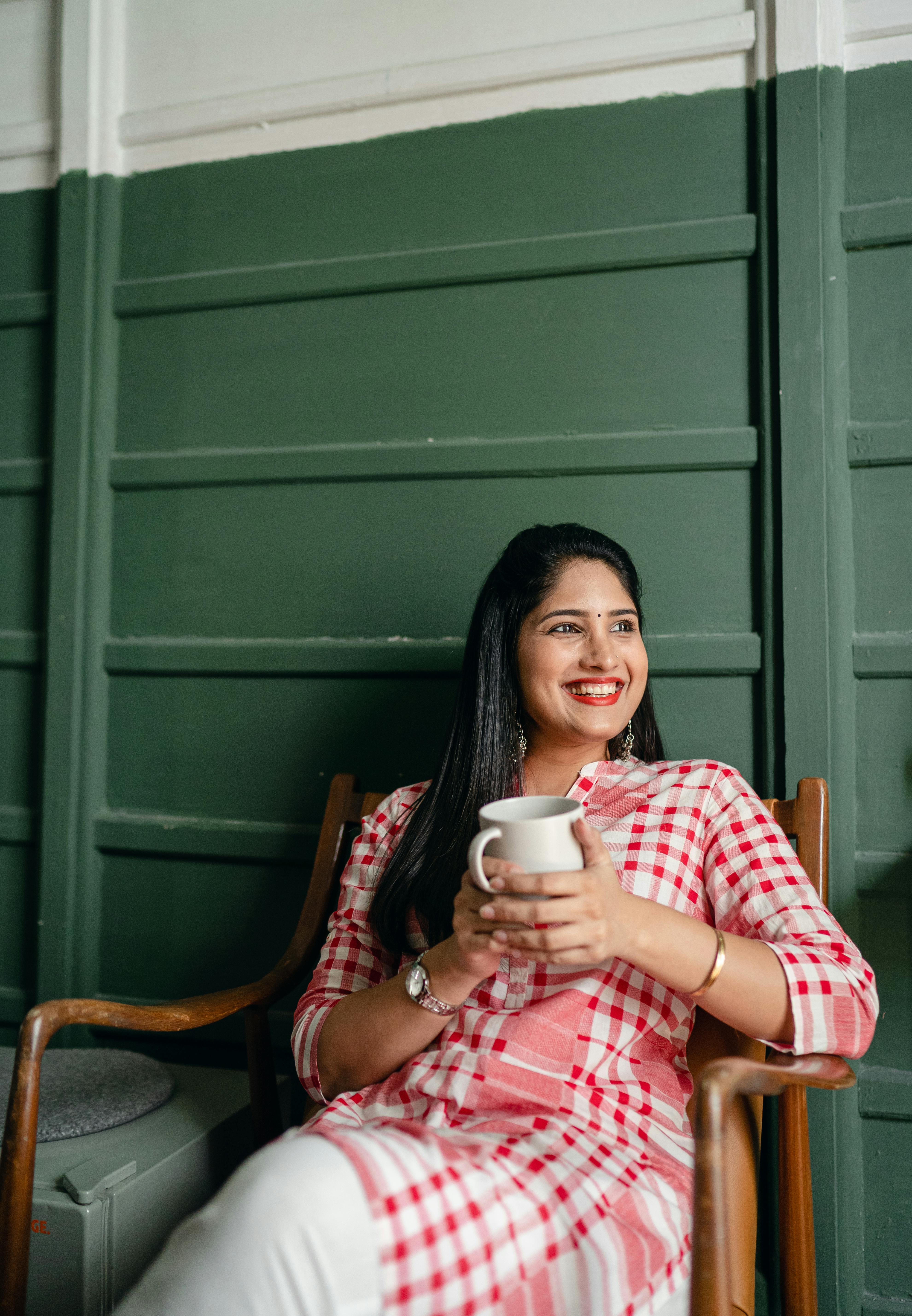Happy woman holding a cup of beverage | Source: Pexels