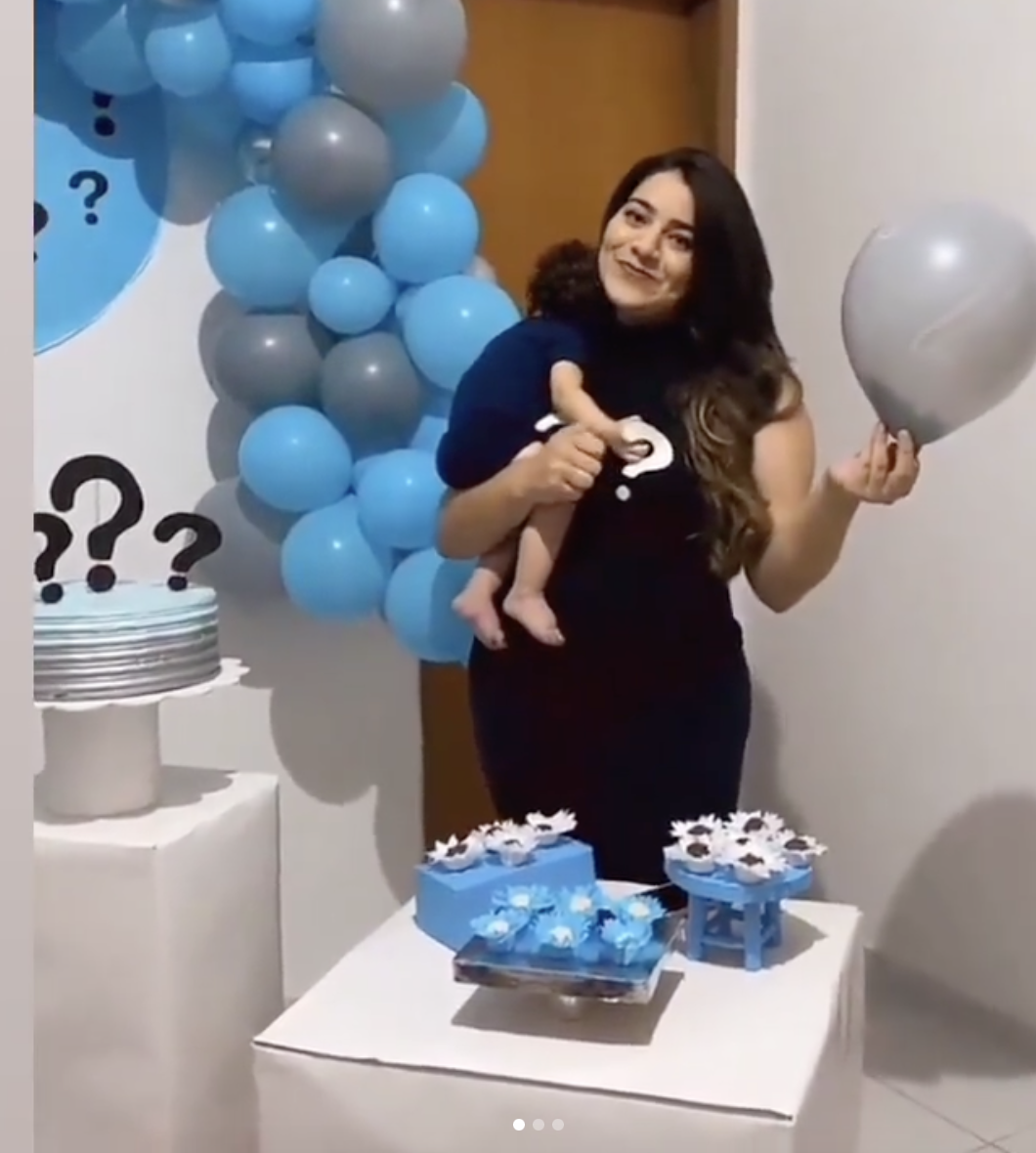 Millena Brandao cradling her son and holding a silver balloon | Source: Instagram.com/milllena.brandao