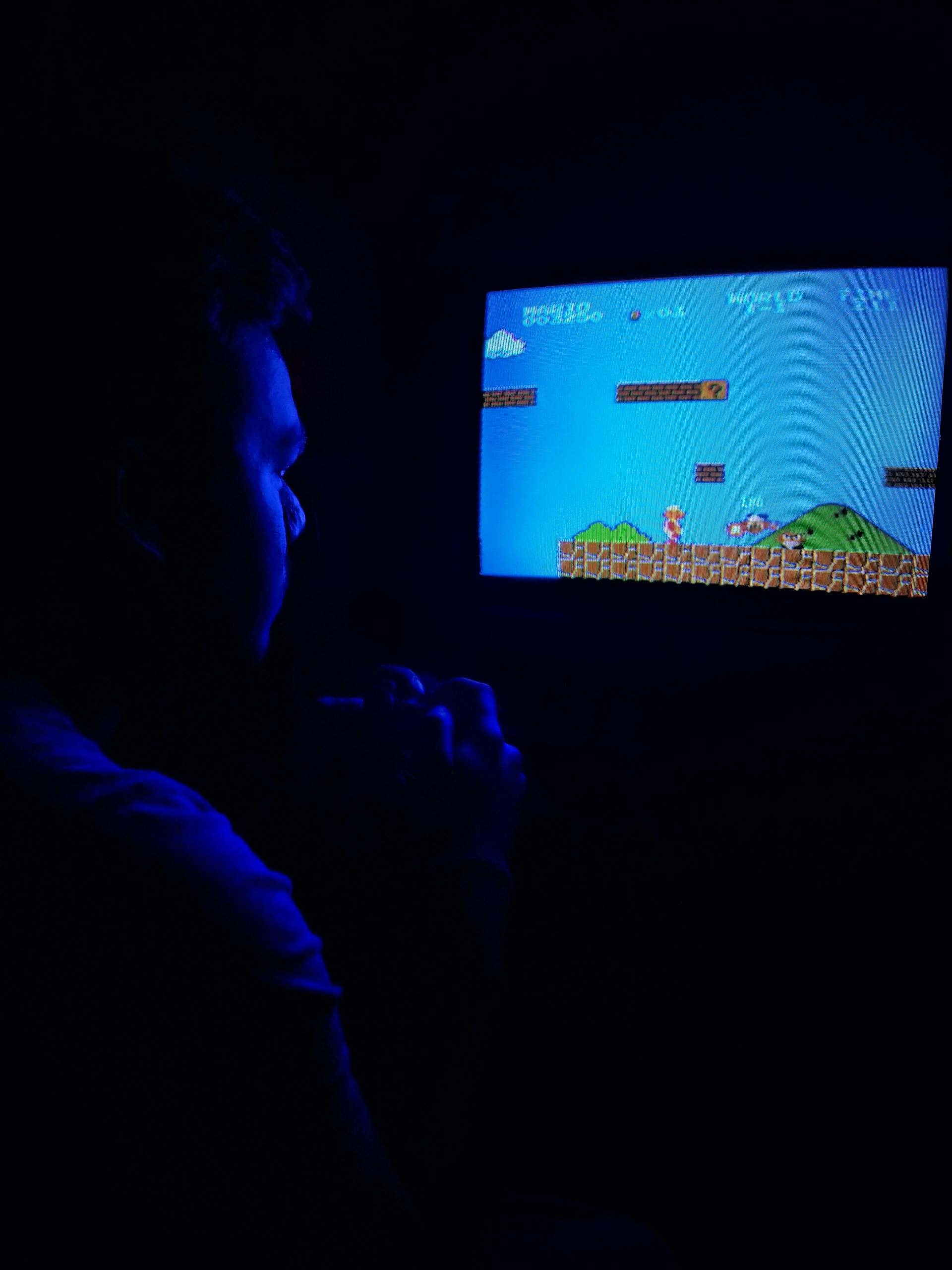 A man playing video games in the dark | Source: Pexels