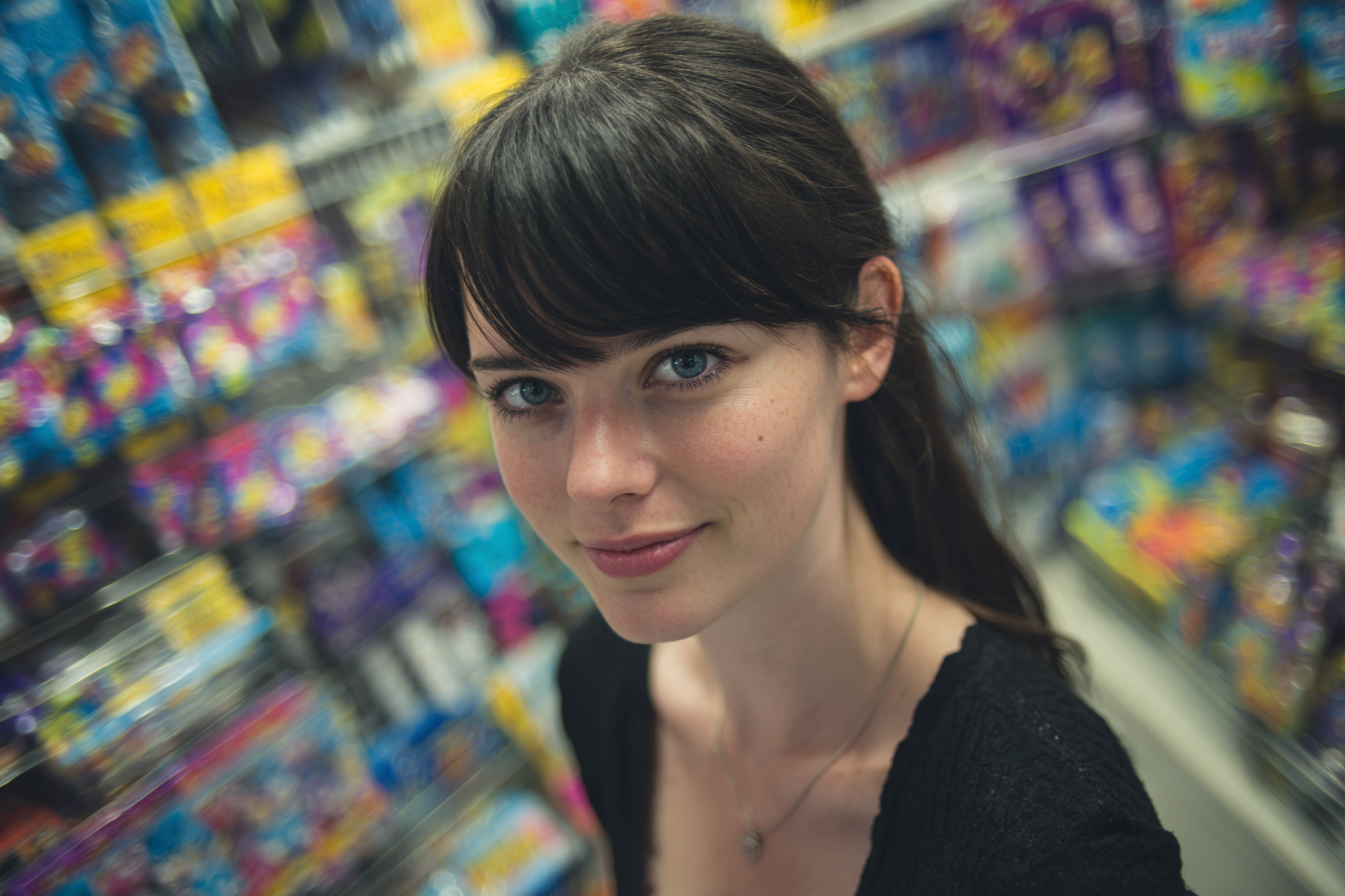 A woman smiling mischievously while shopping in a dollar store | Source: Midjourney