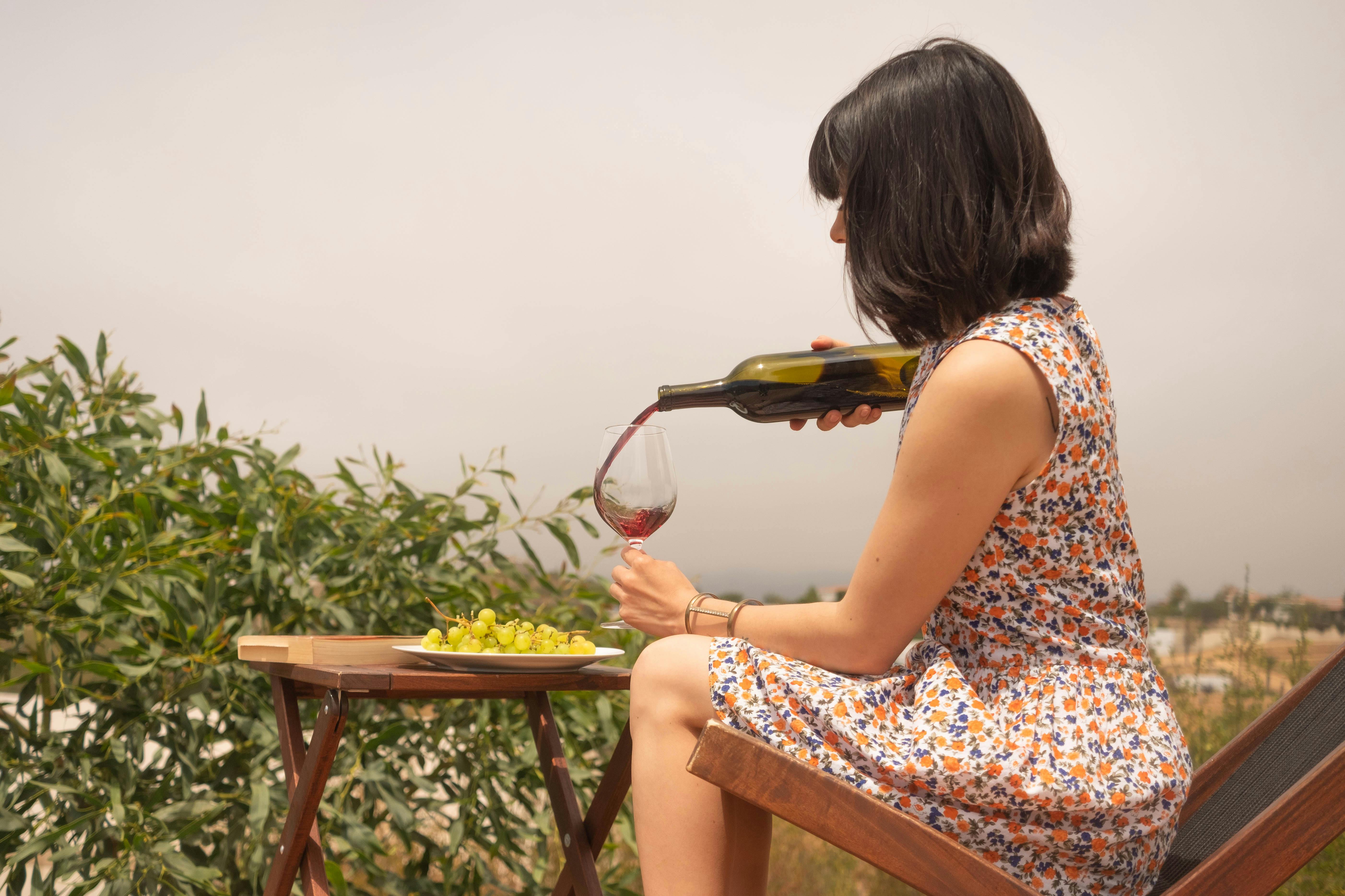 Woman pouring wine in a glass | Source: Pexels