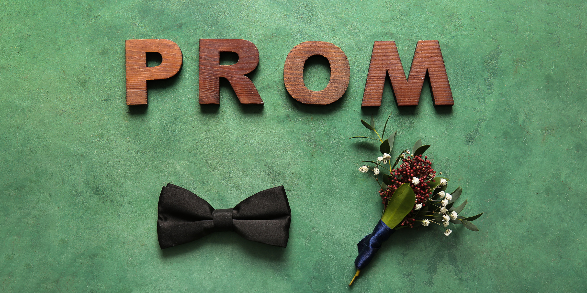 Letters spelling the word 'Prom,' a bow tie, and a buttonhole corsage | Source: Shutterstock