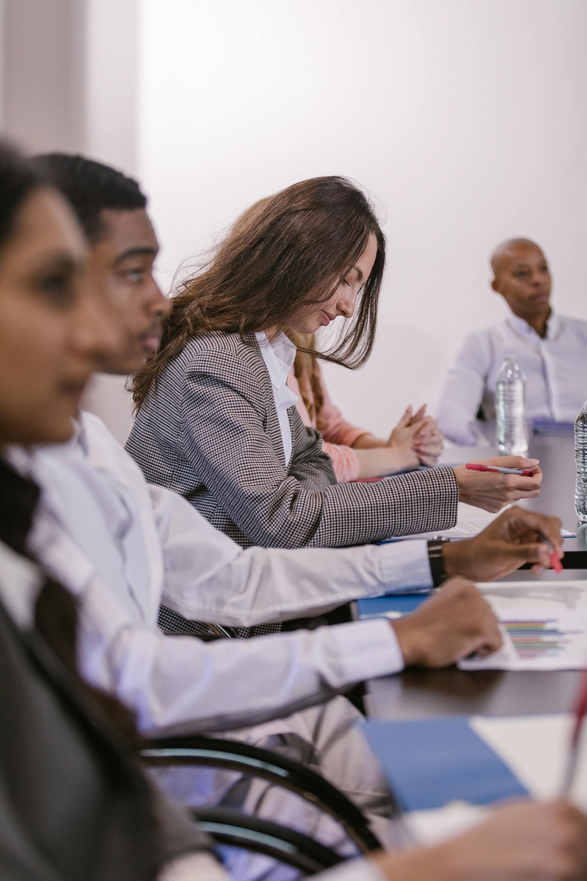 Office workers seated at a conference table | Source: Pexels