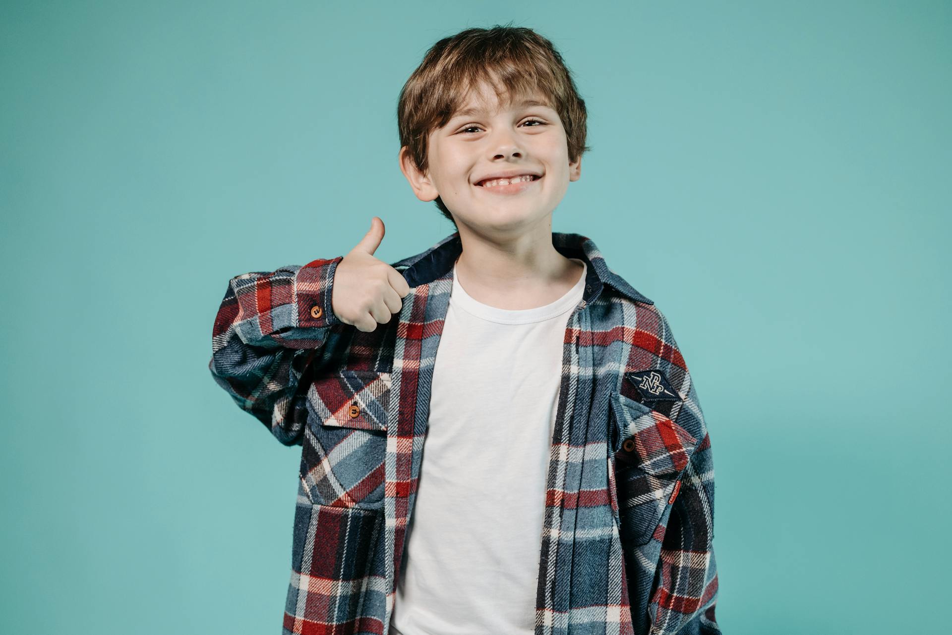 A happy boy giving a thumbs up sign | Source: Pexels