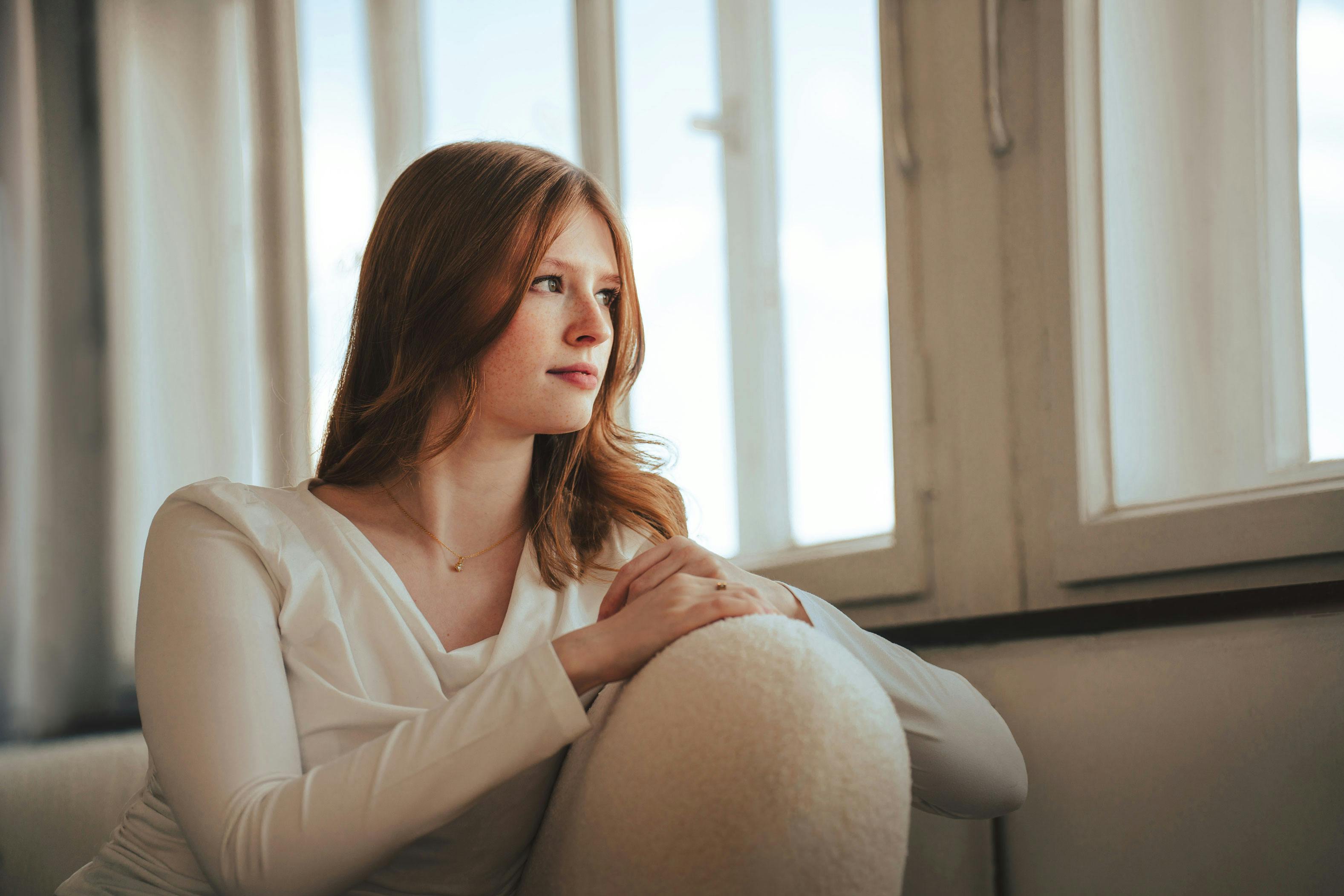 Woman seated on a sofa | Source: Pexels