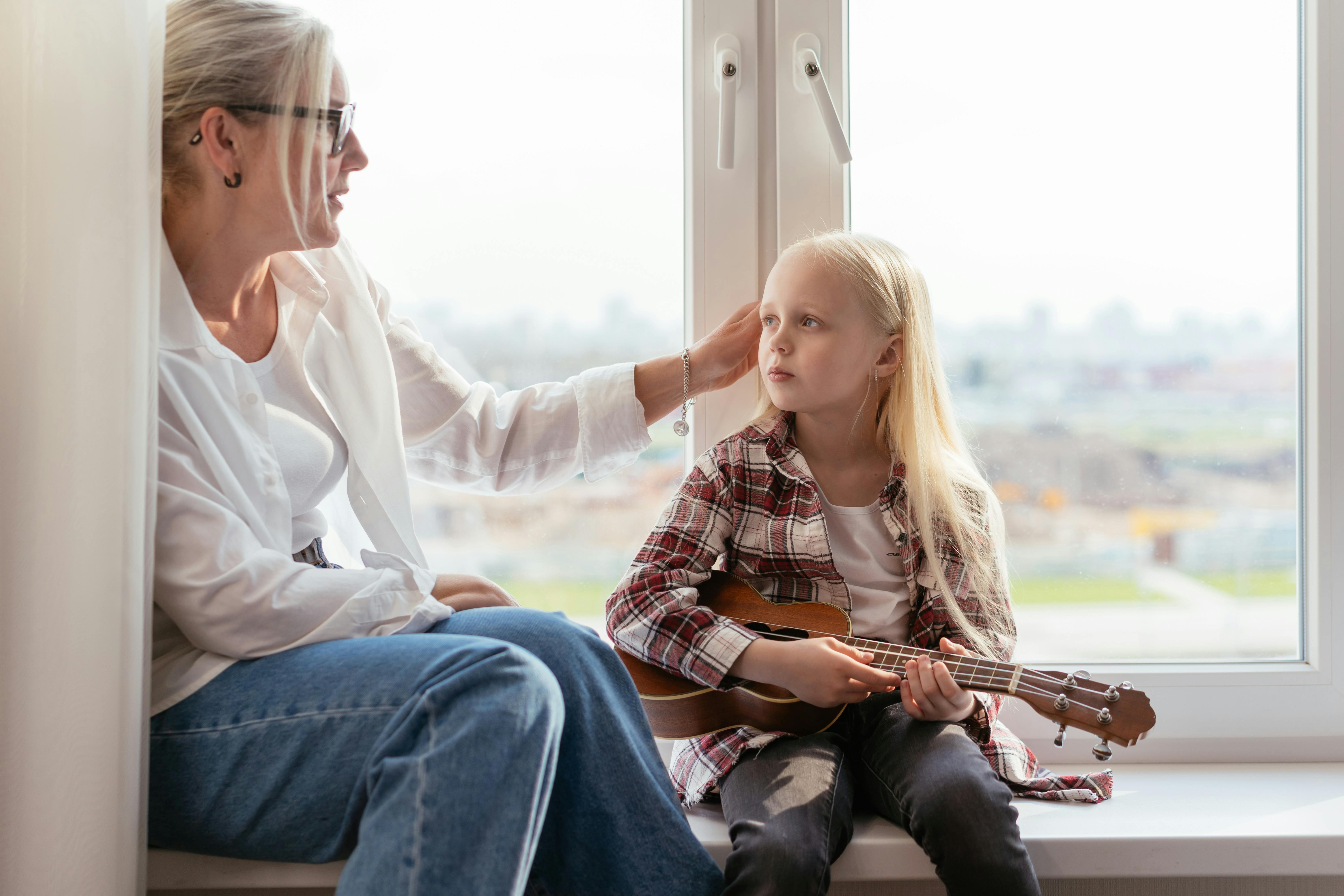 A woman sitting on the windowsill with her grandchild | Source: Pexels