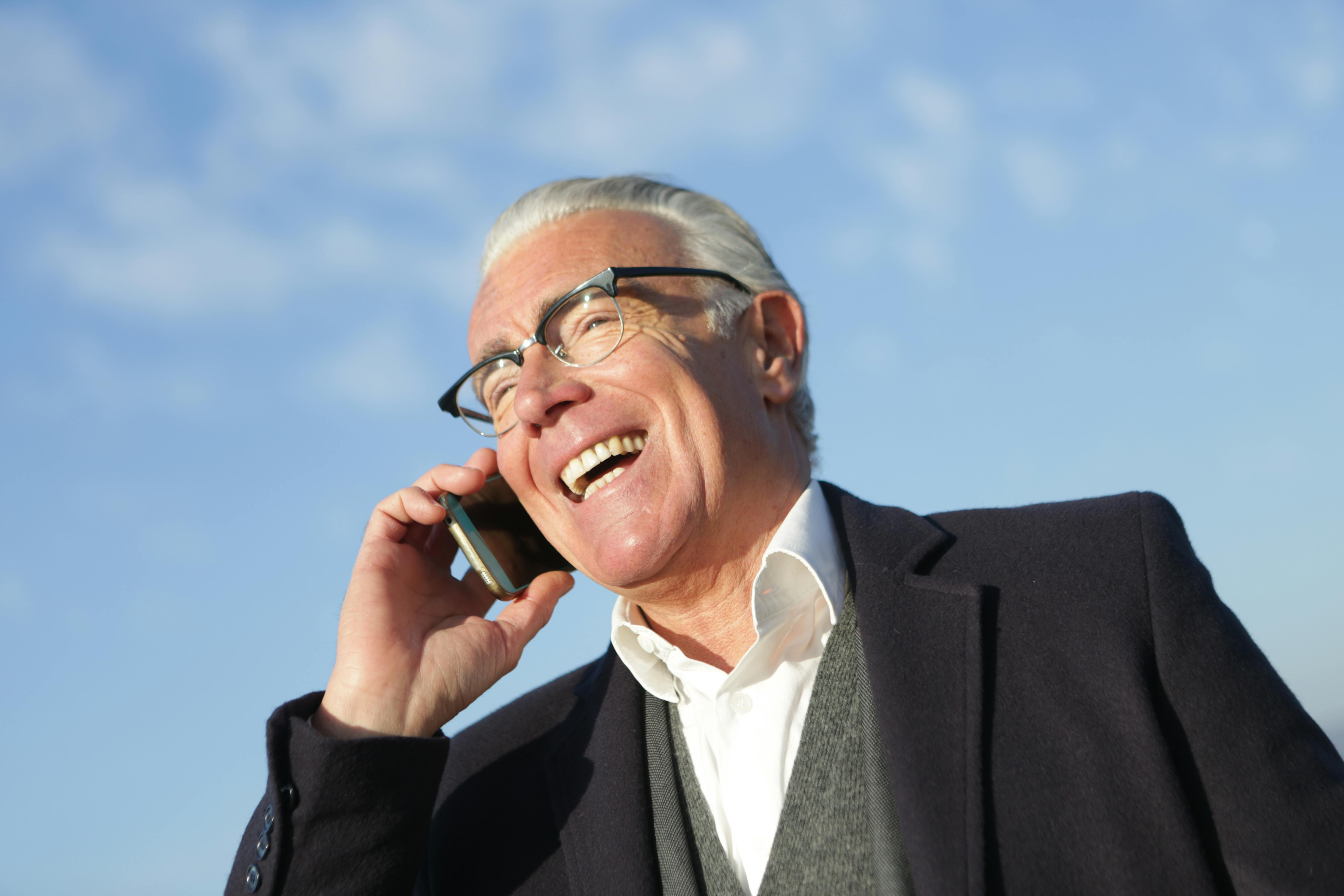 Um homem mais velho feliz ao telefone | Fonte: Pexels