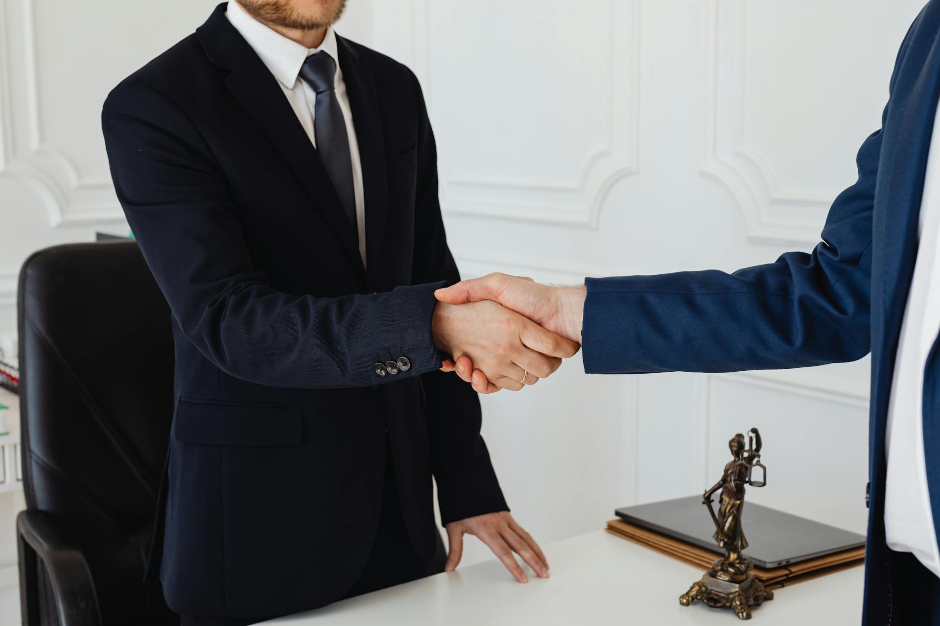 A close-up shot of two men shaking hands in a formal setting | Source: Pexels