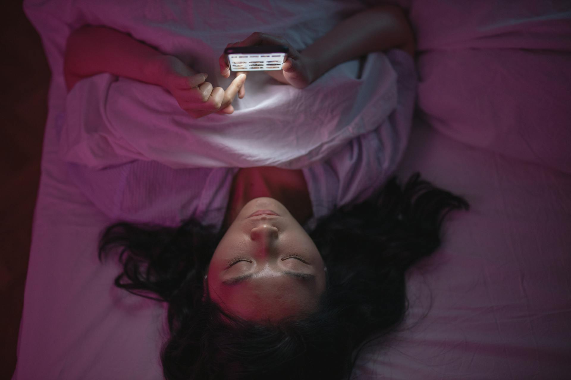 A woman scrolling on her phone in bed | Source: Pexels