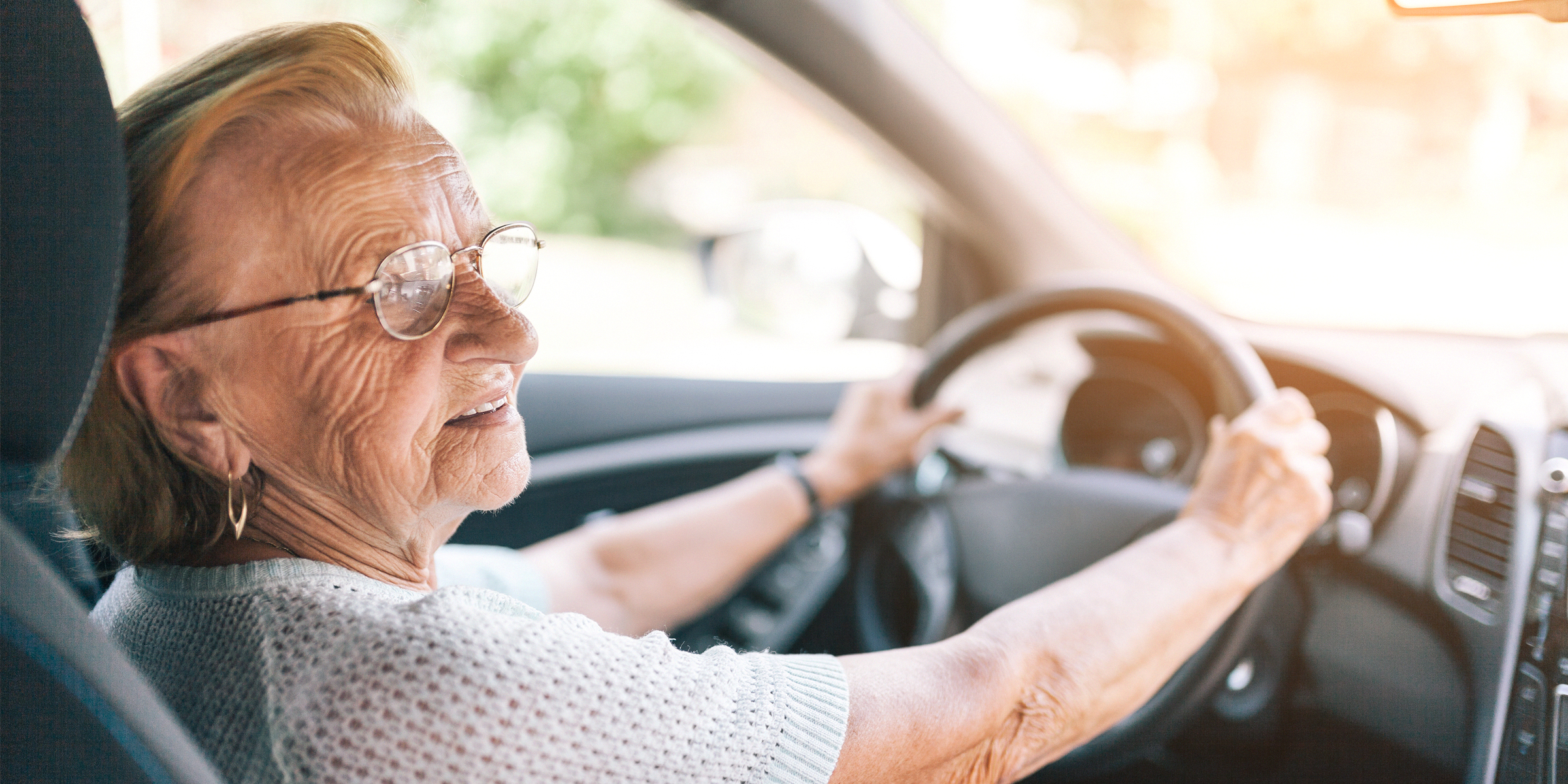 An old woman holding a steering wheel | Source: Shutterstock