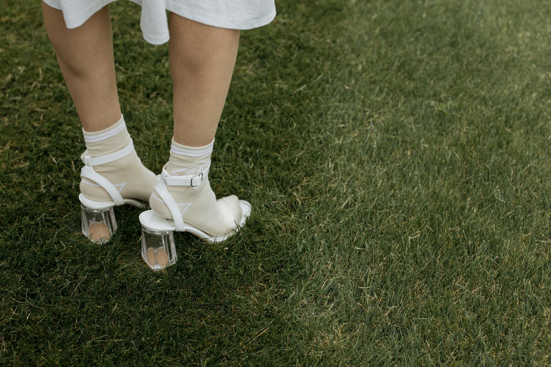 A woman in heels standing on the grass | Source: Pexels
