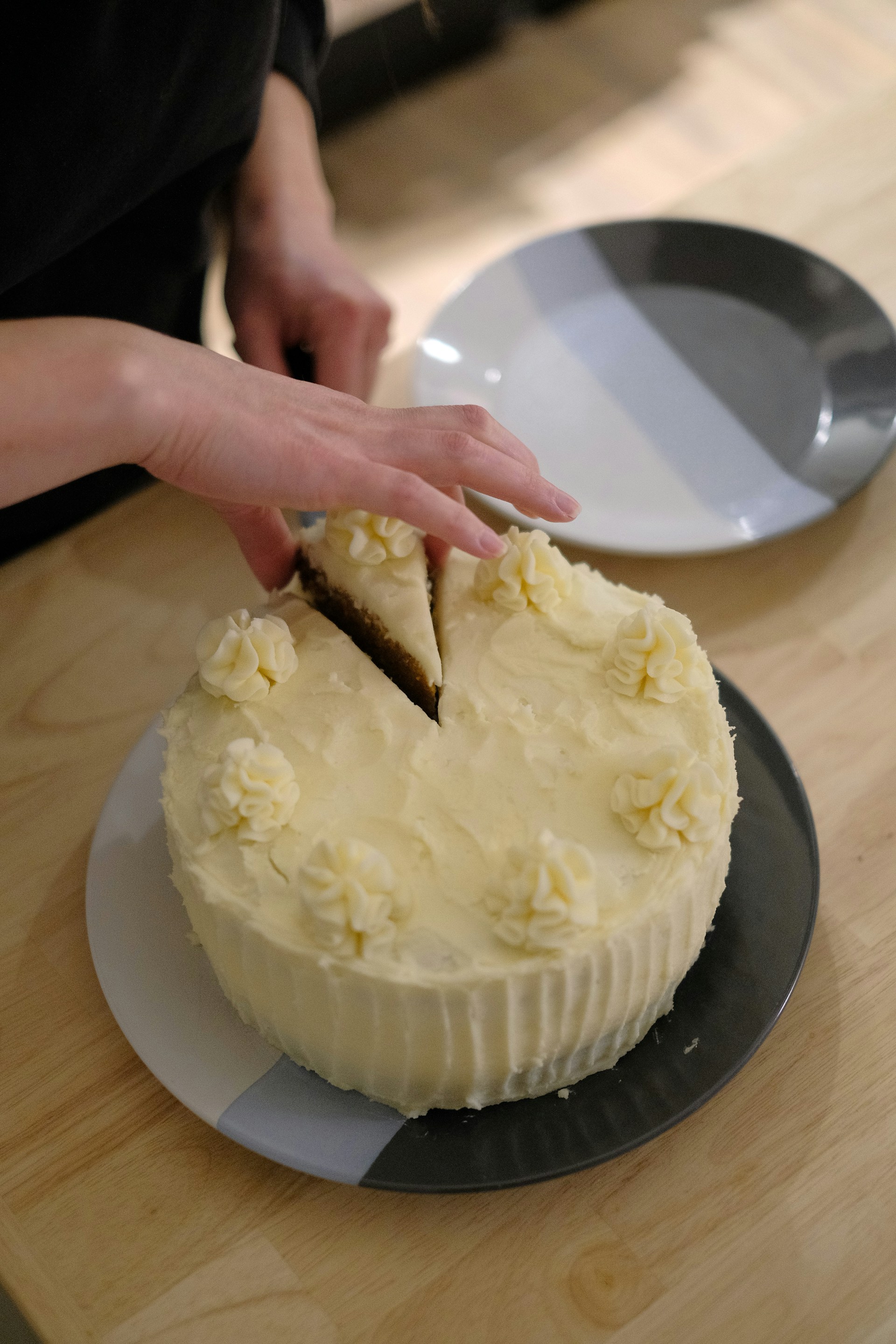 A woman grabbing a slice of cake | Source: Unsplash