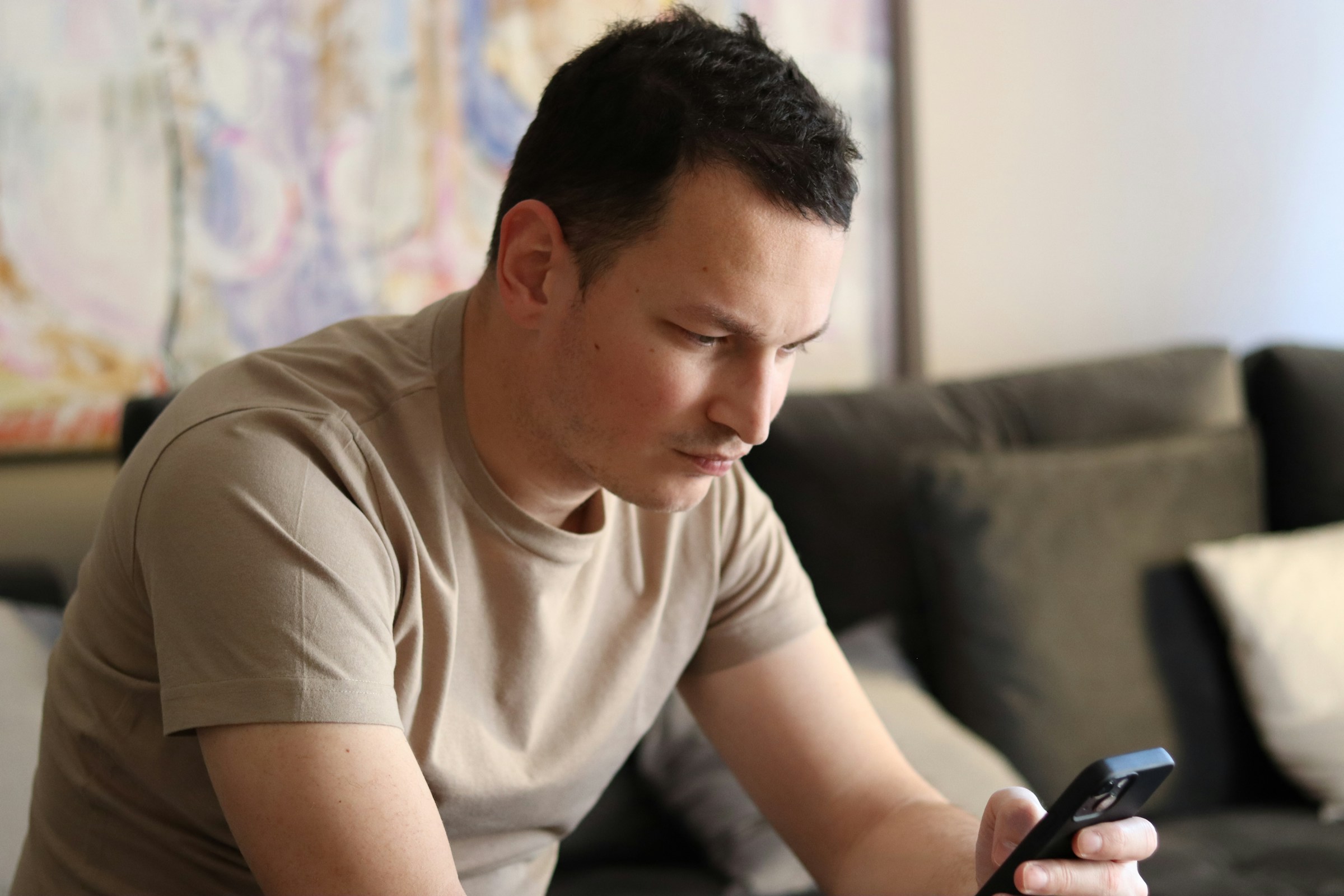 A man with short hair looking at his phone | Source: Unsplash