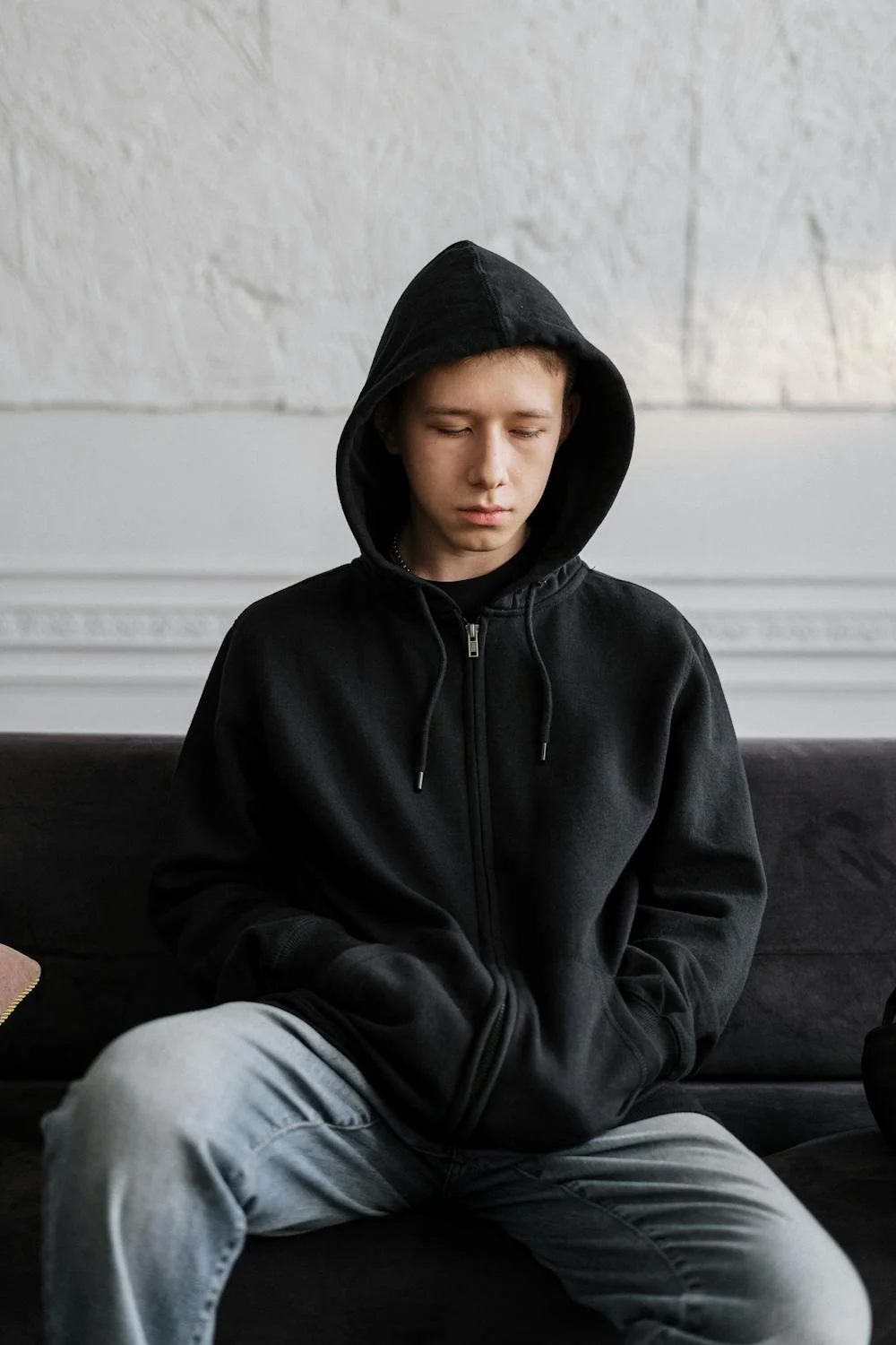 A sad boy in a black hoodie | Source: Pexels